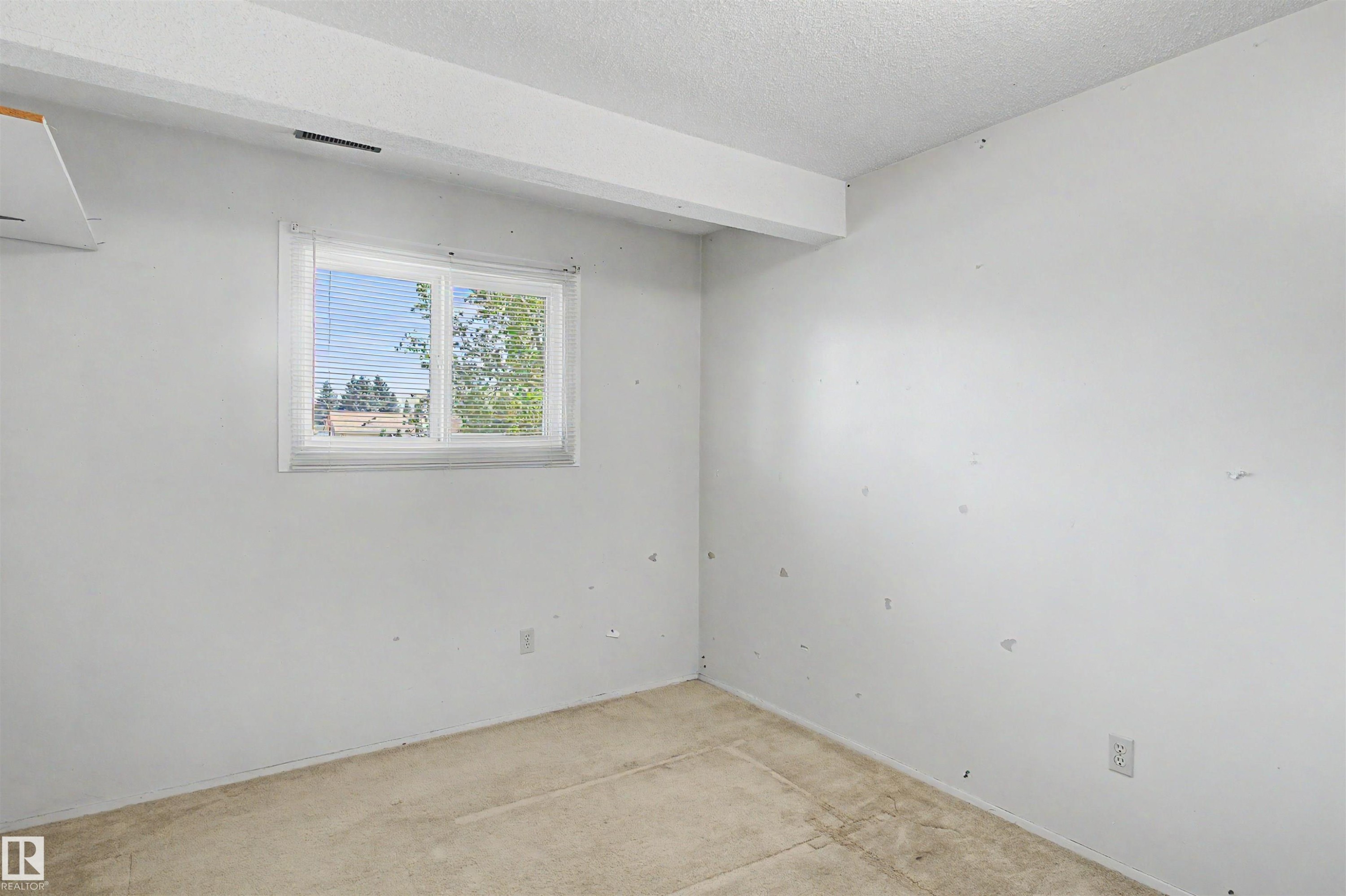 Room featuring a window with horizontal blinds, providing natural light - 5953 40 Avenue, Edmonton, AB