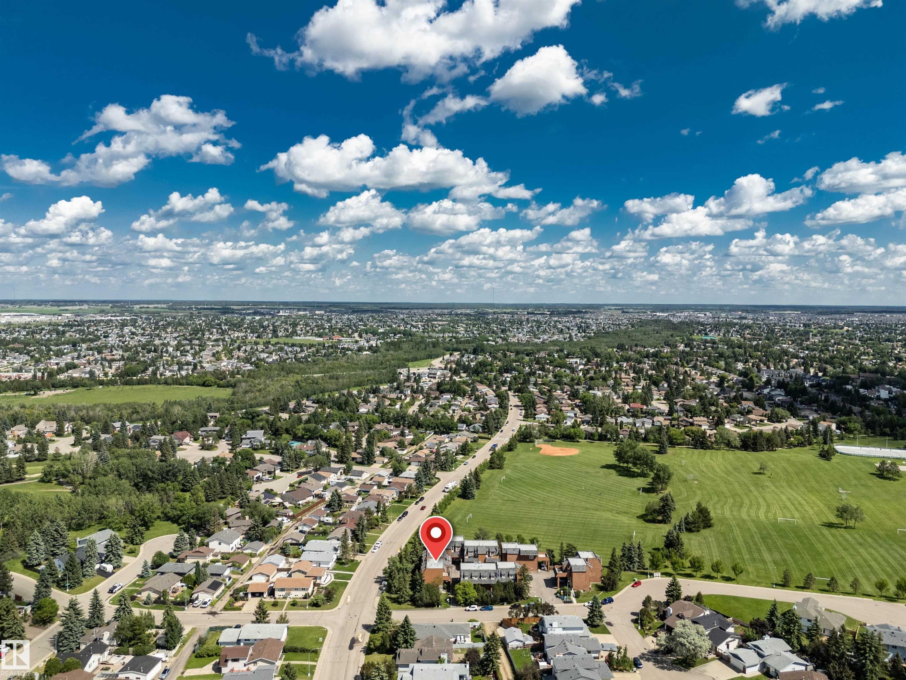 Aerial perspective showcasing the surrounding residential landscape and expansive green spaces - 5953 40 Avenue, Edmonton, AB