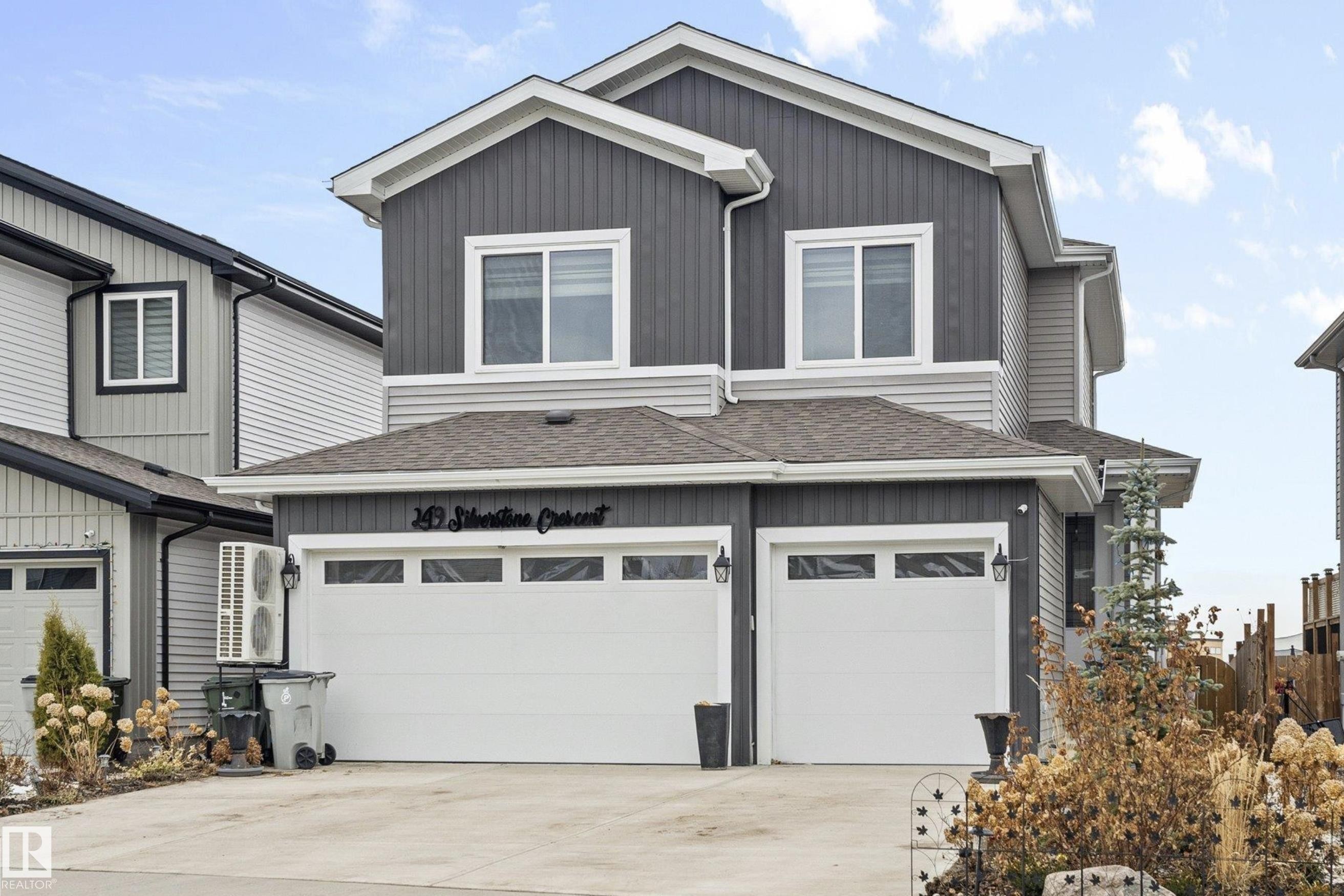 Contemporary two-story residence featuring a dual-tone facade with dark vertical siding and light horizontal siding - 249 Silverstone Crescent, Stony Plain, AB - Outdoor