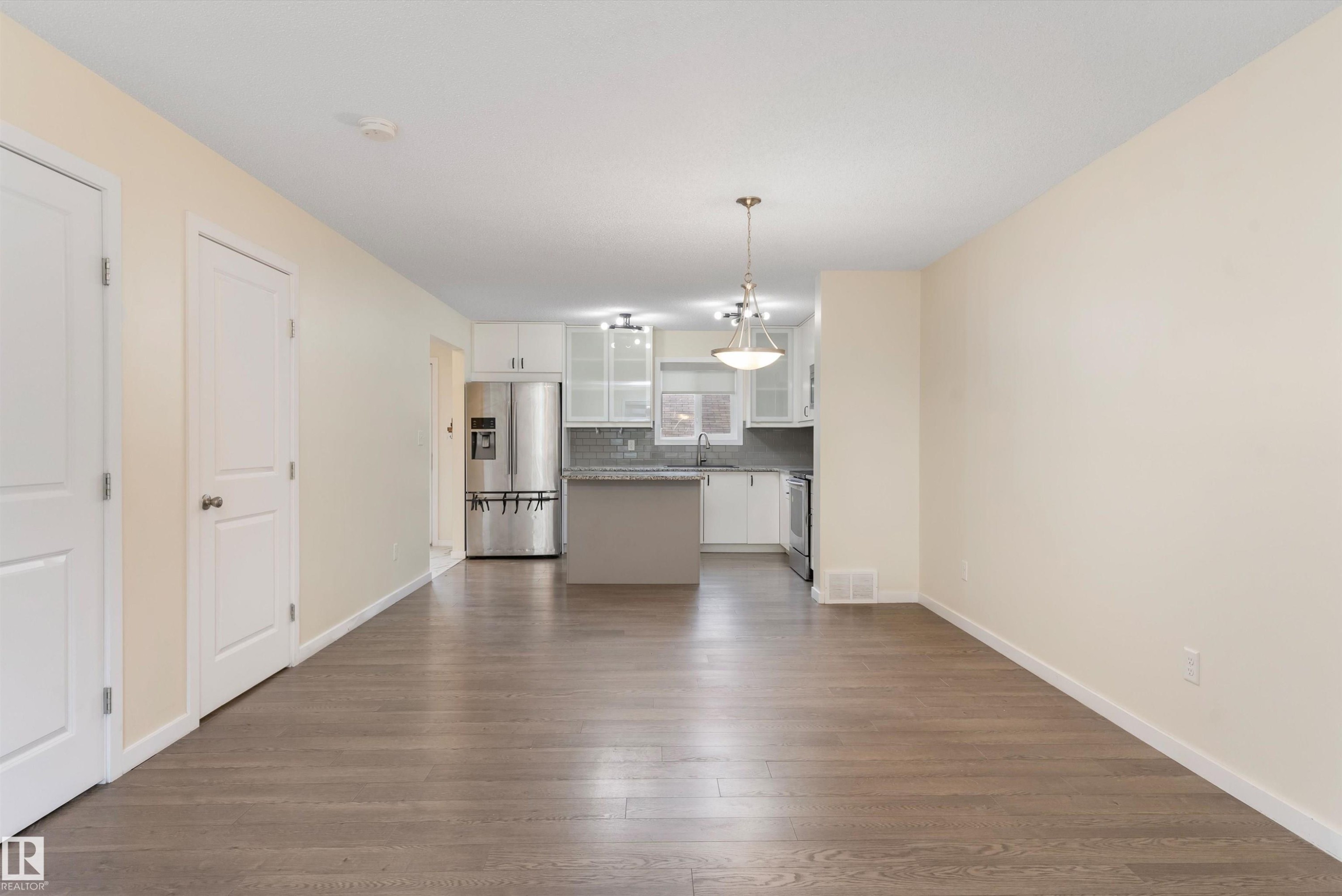 Open-concept living area featuring wood-finish flooring, light-toned walls, and white trim - 336 Watt Boulevard, Edmonton, AB - Indoor Photo Showing Other Room