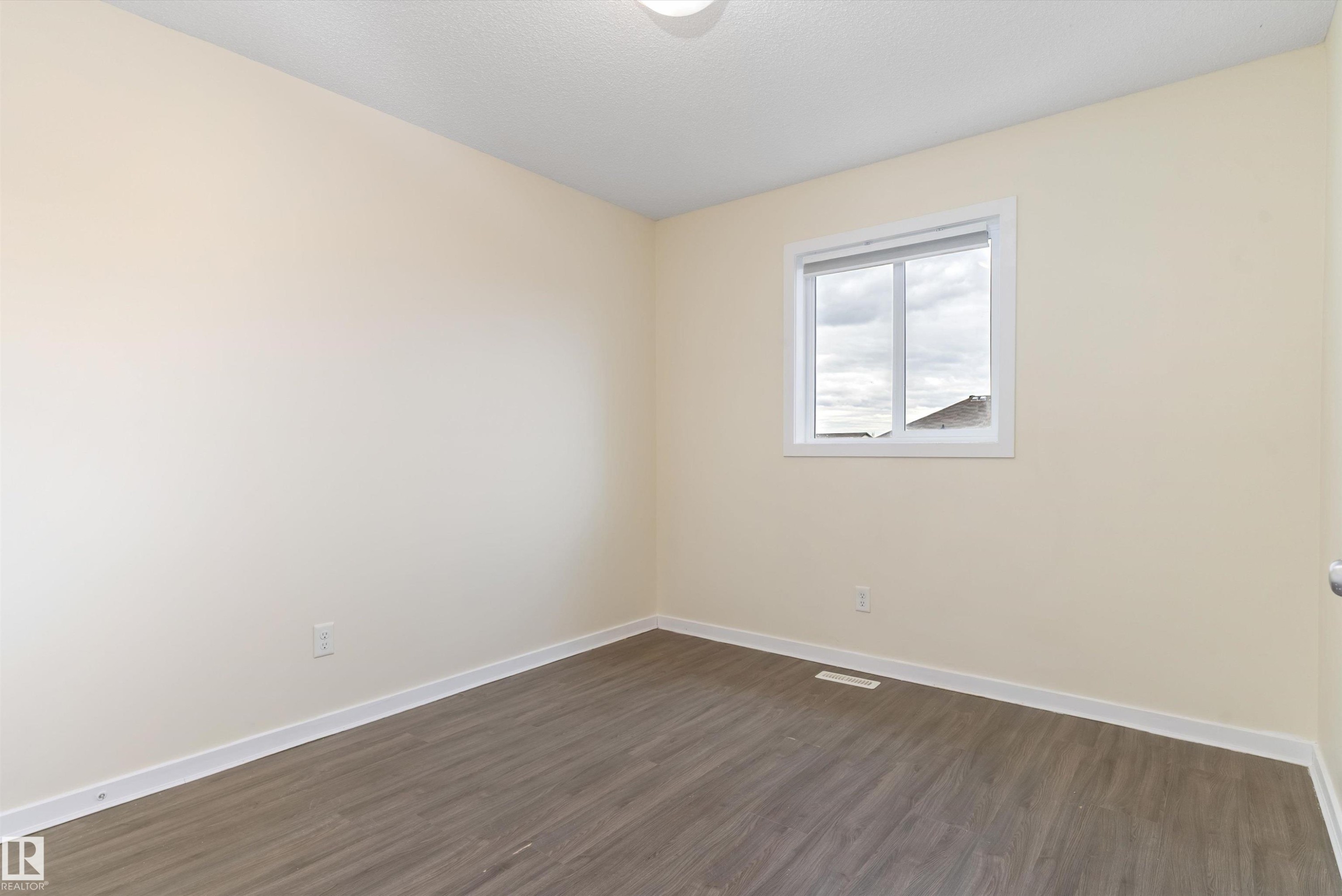 Neutral-toned room featuring wood-finish flooring, white baseboards, and a single window with white trim - 336 Watt Boulevard, Edmonton, AB - Indoor Photo Showing Other Room