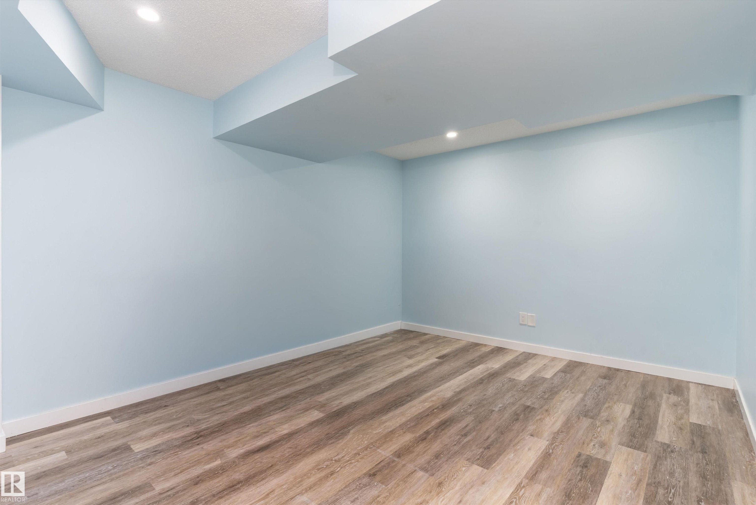 Room featuring wood-finish flooring, light blue painted walls, recessed lighting, white baseboards, and a textured white ceiling - 336 Watt Boulevard, Edmonton, AB - Indoor Photo Showing Other Room