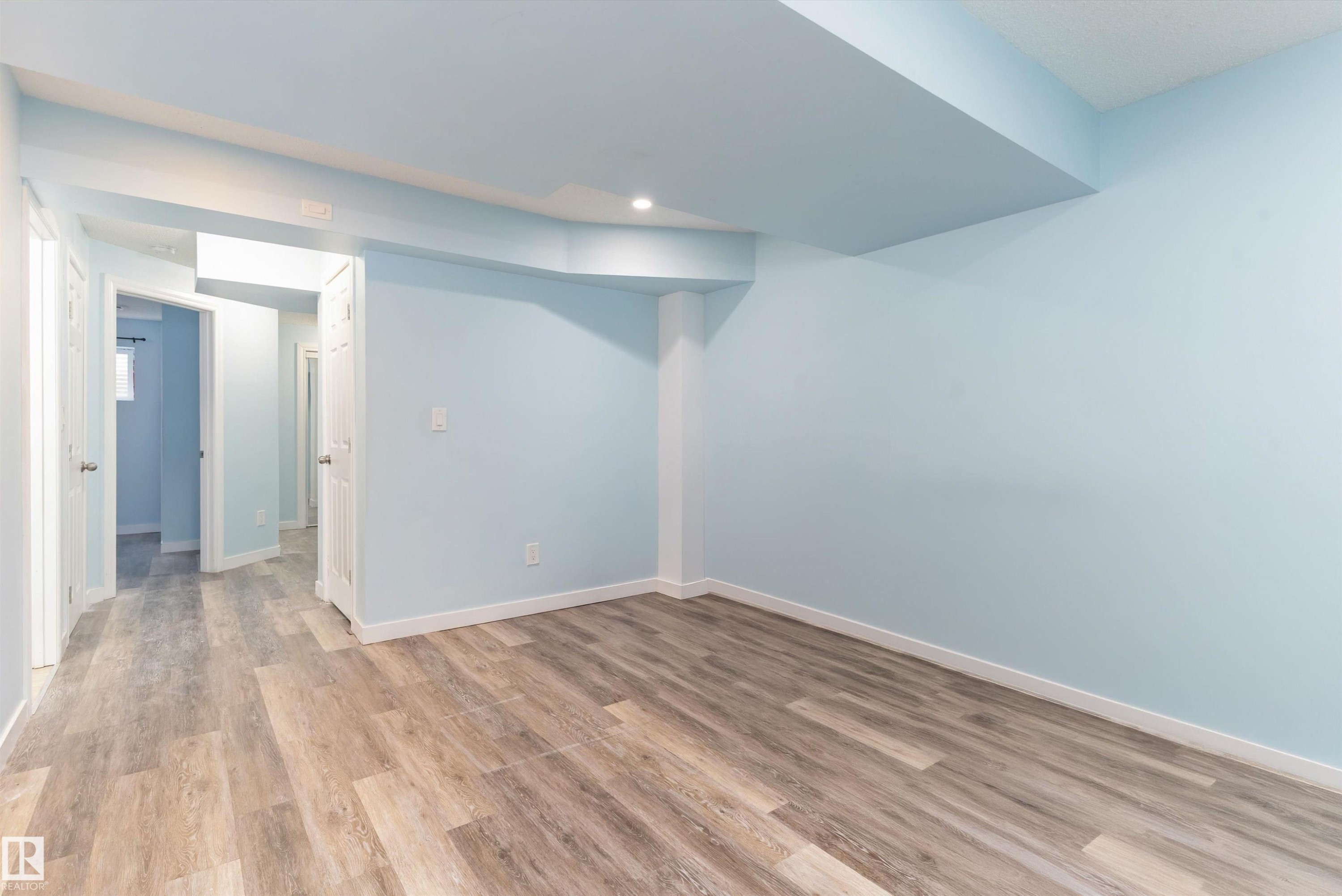 Spacious interior room with light blue walls and wood-finish flooring - 336 Watt Boulevard, Edmonton, AB - Indoor Photo Showing Other Room