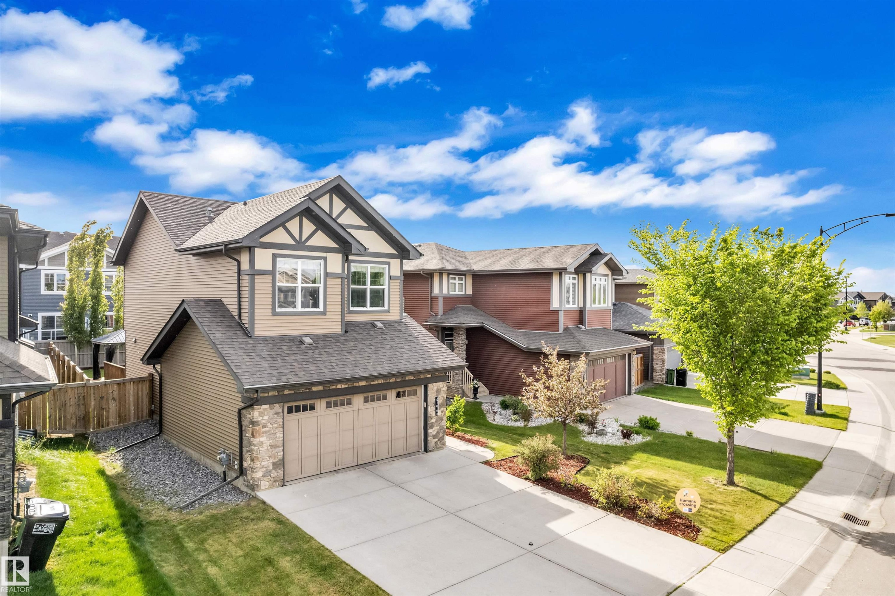 The property features a two-car garage, a concrete driveway, and a well-maintained lawn - 8108 217 Street, Edmonton, AB - Outdoor