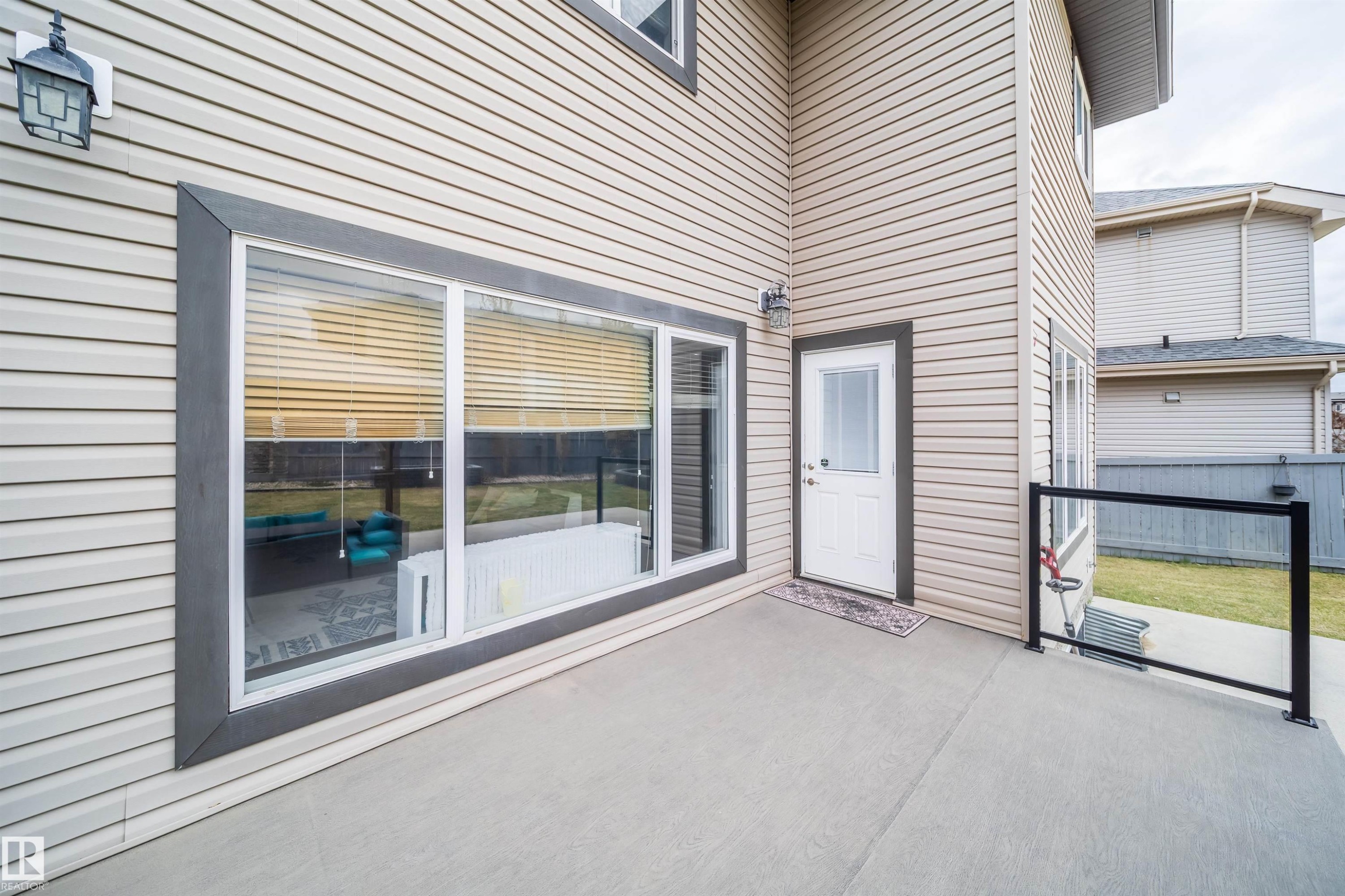 Expansive concrete patio with glass panel railing - 1508 Cunningham Cape Cape, Edmonton, AB - Outdoor With Exterior