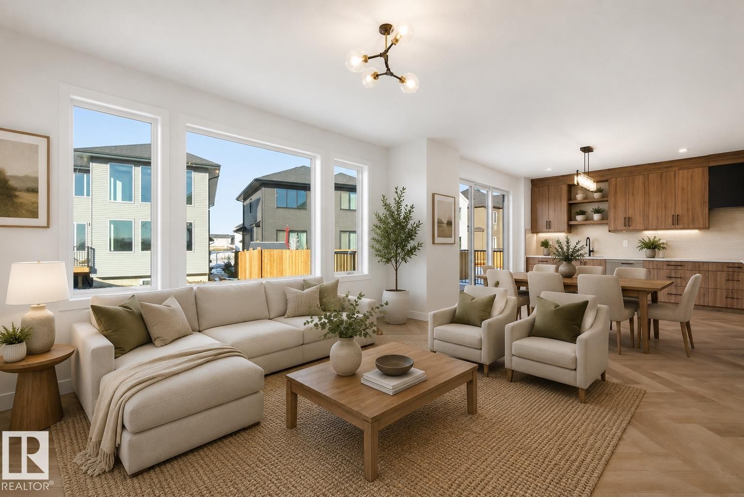 Open-concept living area featuring a spacious layout, large windows, wood-finish flooring, a contemporary kitchen with wood cabinetry, and a dining area with a modern chandelier - 17108 2 Street, Edmonton, AB - Indoor Photo Showing Living Room