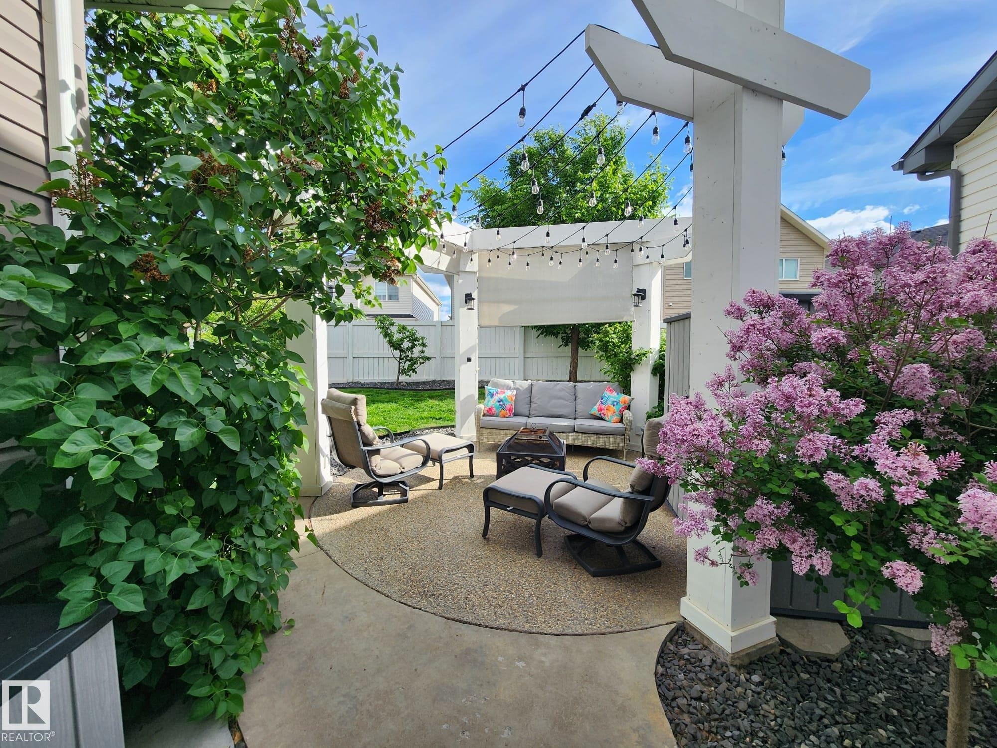 Private patio space with a white pergola and string lighting - 22933 94A Avenue, Edmonton, AB - Outdoor