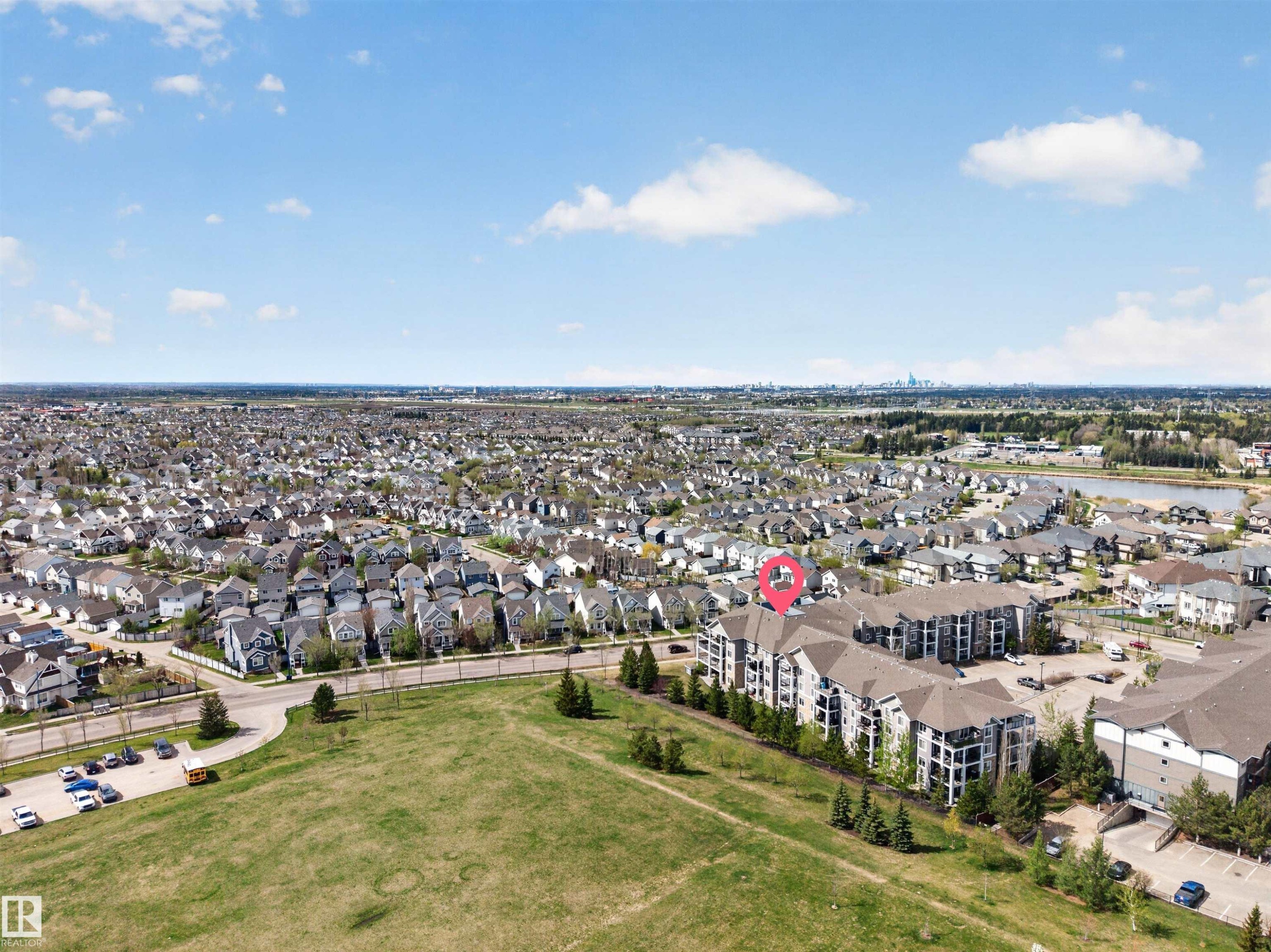 Contemporary multi-story building featuring balconies and a large surface parking area - 215 6084 Stanton Drive, Edmonton, AB - Outdoor With View