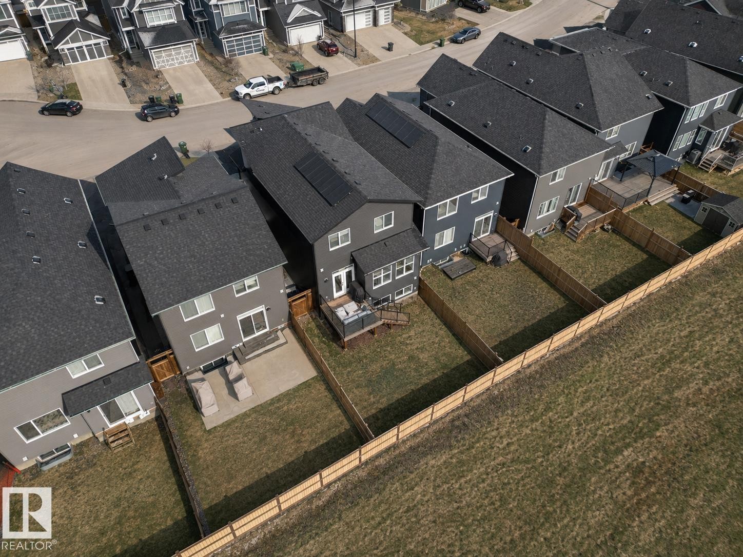 Modern residential exterior featuring a rear patio, private fenced yard, and multi-level decking - 19 Sturtz Place, Leduc, AB -