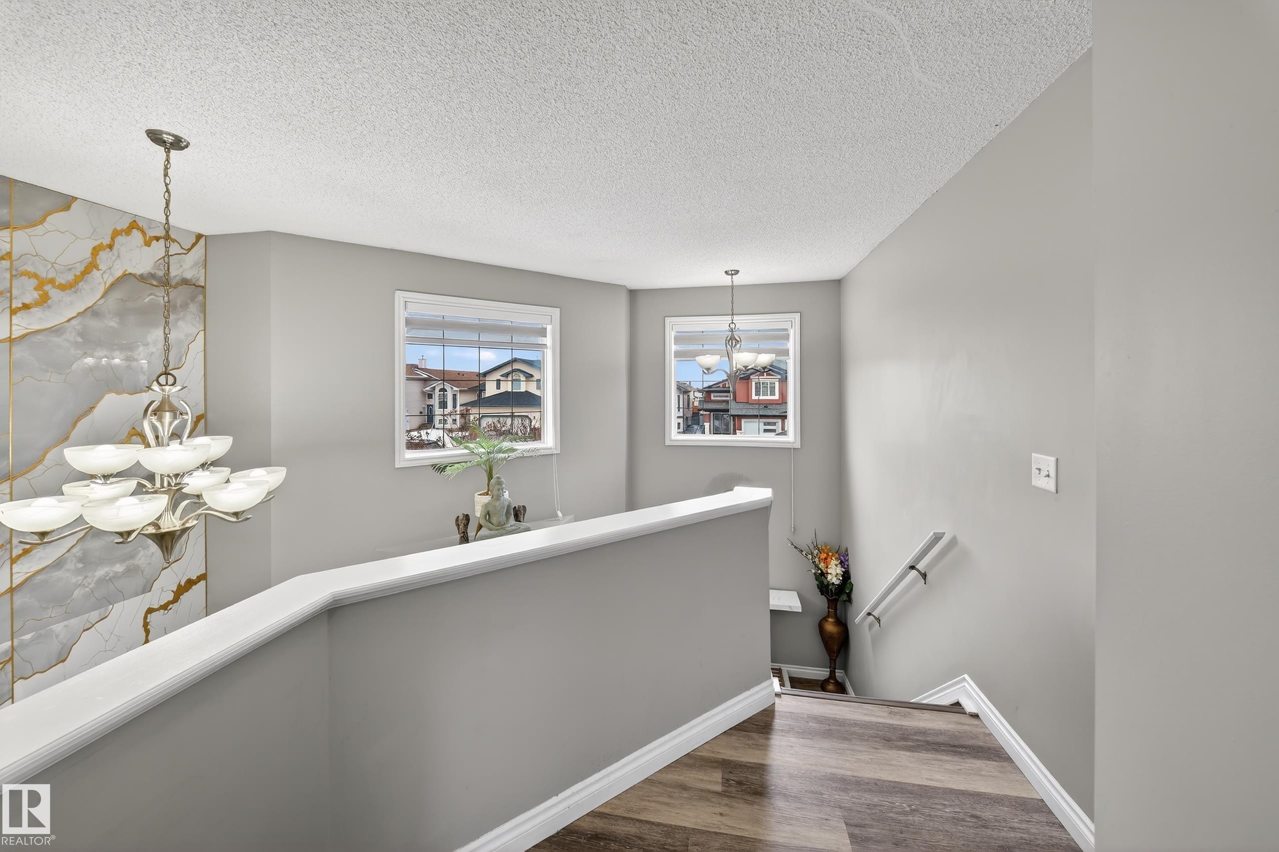 Well-lit interior space featuring two windows, a light fixture with multiple bowls, and light-toned walls - 3517 25 Street, Edmonton, AB - Indoor Photo Showing Other Room