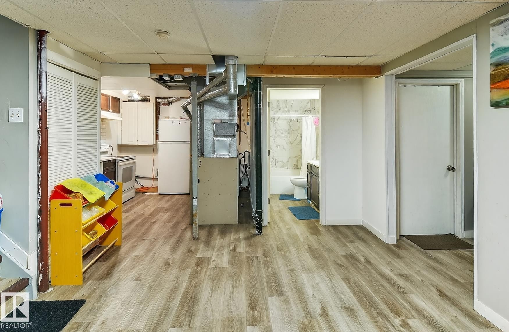 The property features durable flooring, a well-lit kitchen area with white appliances, and a bathroom with a shower and toilet - 3517 25 Street, Edmonton, AB - Indoor