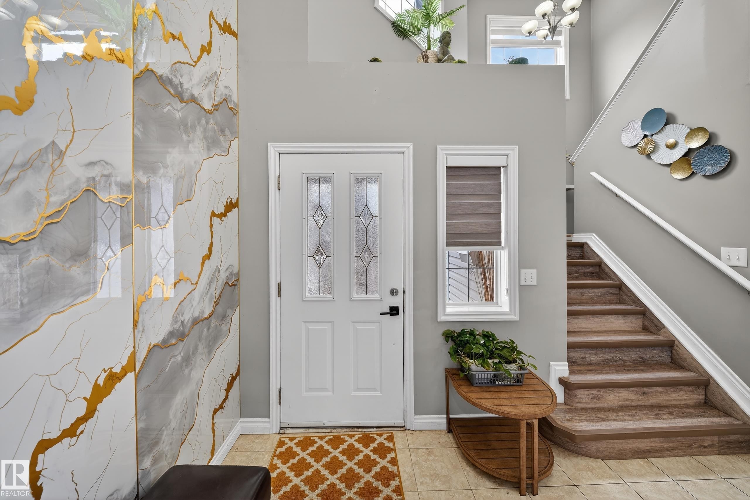 Entryway featuring a decorative wall, a white door with decorative glass inserts, and a staircase with wood-look treads and white risers - 3517 25 Street, Edmonton, AB - Indoor Photo Showing Other Room