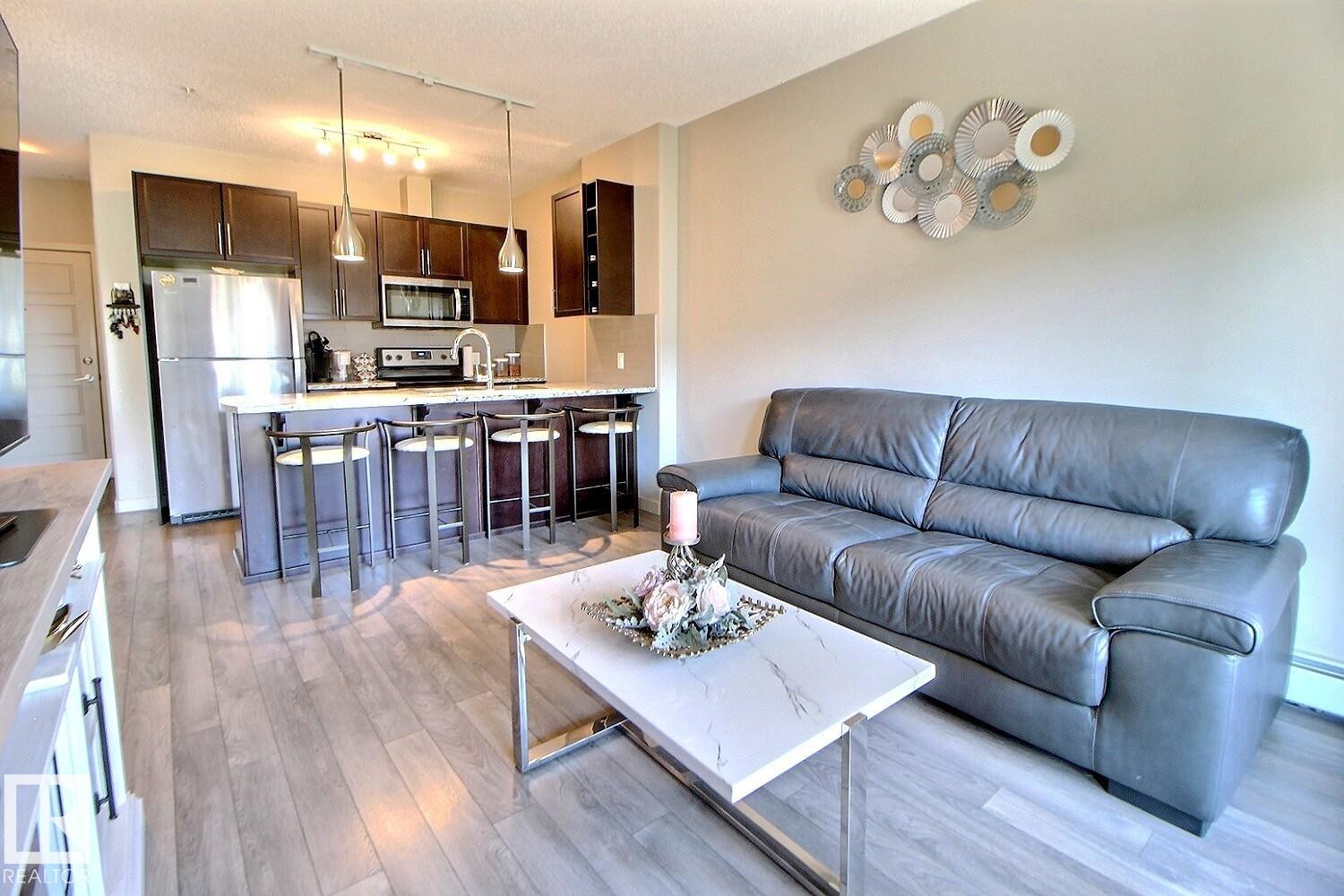 Open-concept living space featuring wood-finish flooring - 327 508 Griesbach Parade, Edmonton, AB - Indoor