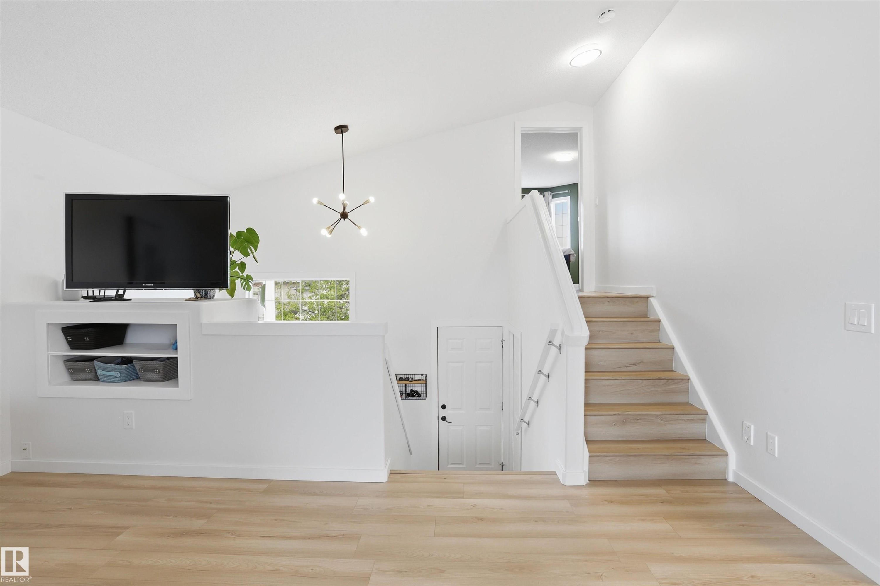 Vaulted ceiling interior featuring light wood-finish flooring - 396 Kananaskis Way, Devon, AB - Indoor Photo Showing Other Room