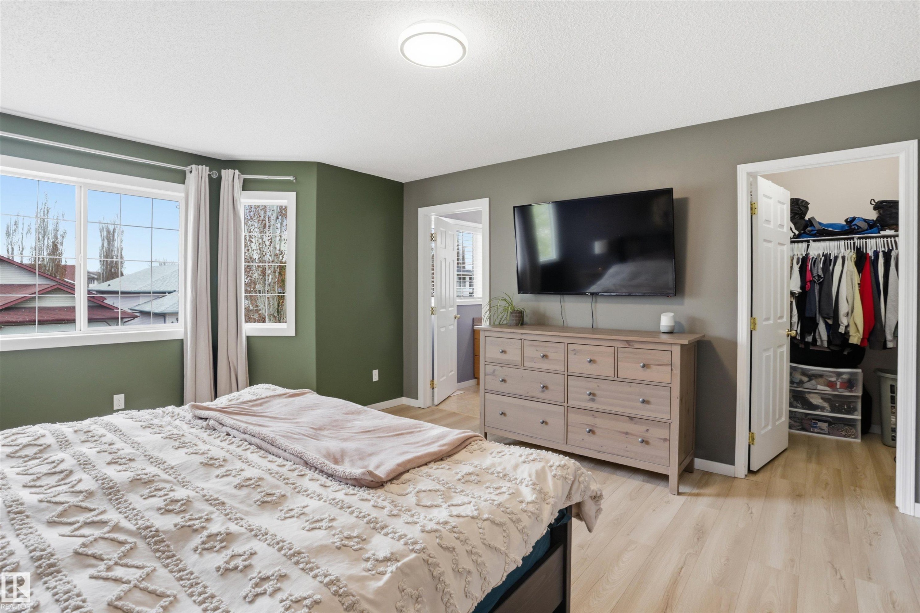 Bedroom featuring light wood-finish flooring and deep green wall paint - 396 Kananaskis Way, Devon, AB - Indoor Photo Showing Bedroom