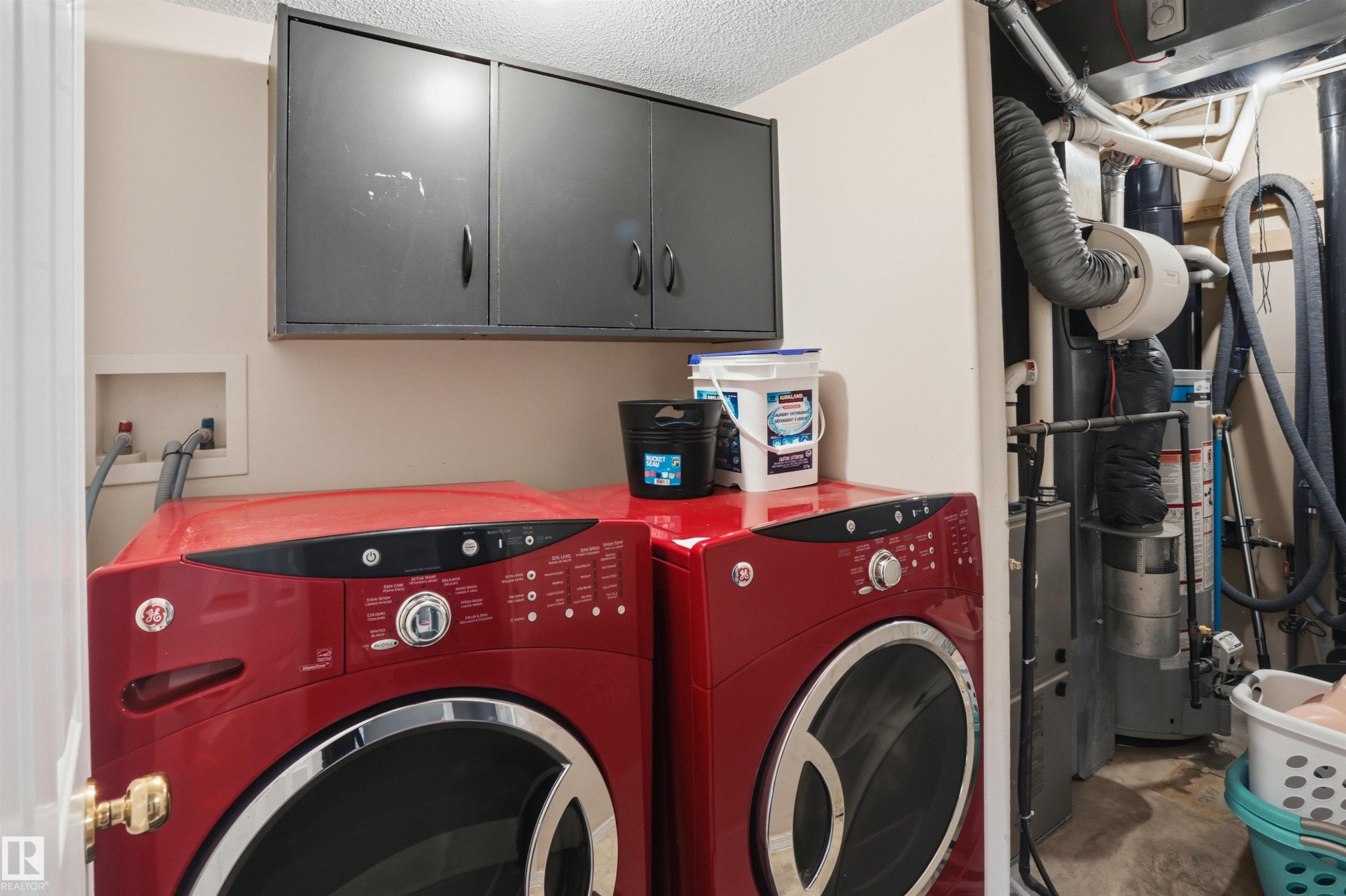 Laundry area featuring wall-mounted cabinetry, washer and dryer hookups, and a built-in utility closet housing mechanical equipment - 396 Kananaskis Way, Devon, AB - Indoor Photo Showing Laundry Room