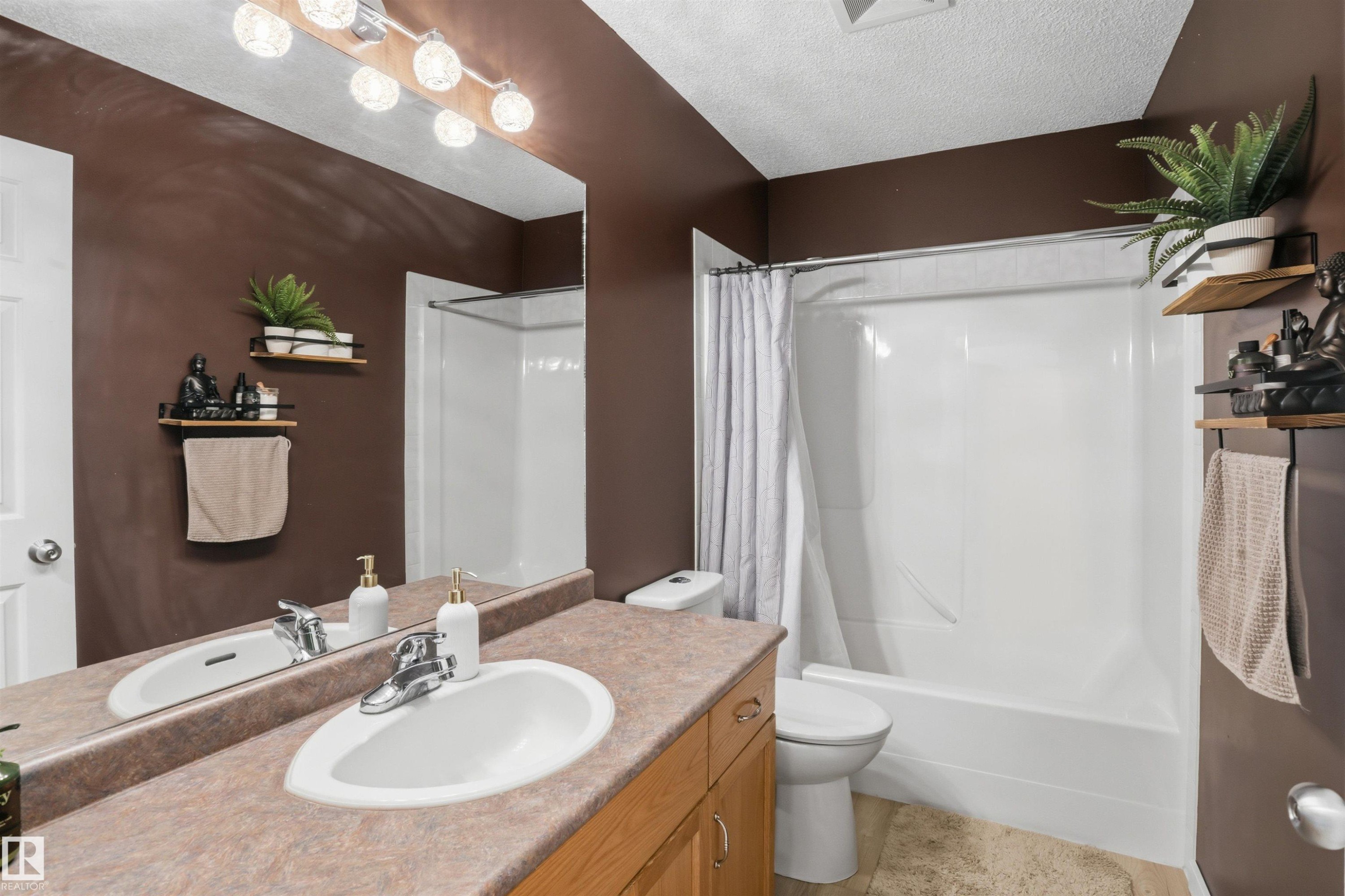 Bathroom featuring a single vanity with a laminate countertop, an integrated sink, and a chrome faucet - 396 Kananaskis Way, Devon, AB - Indoor Photo Showing Bathroom