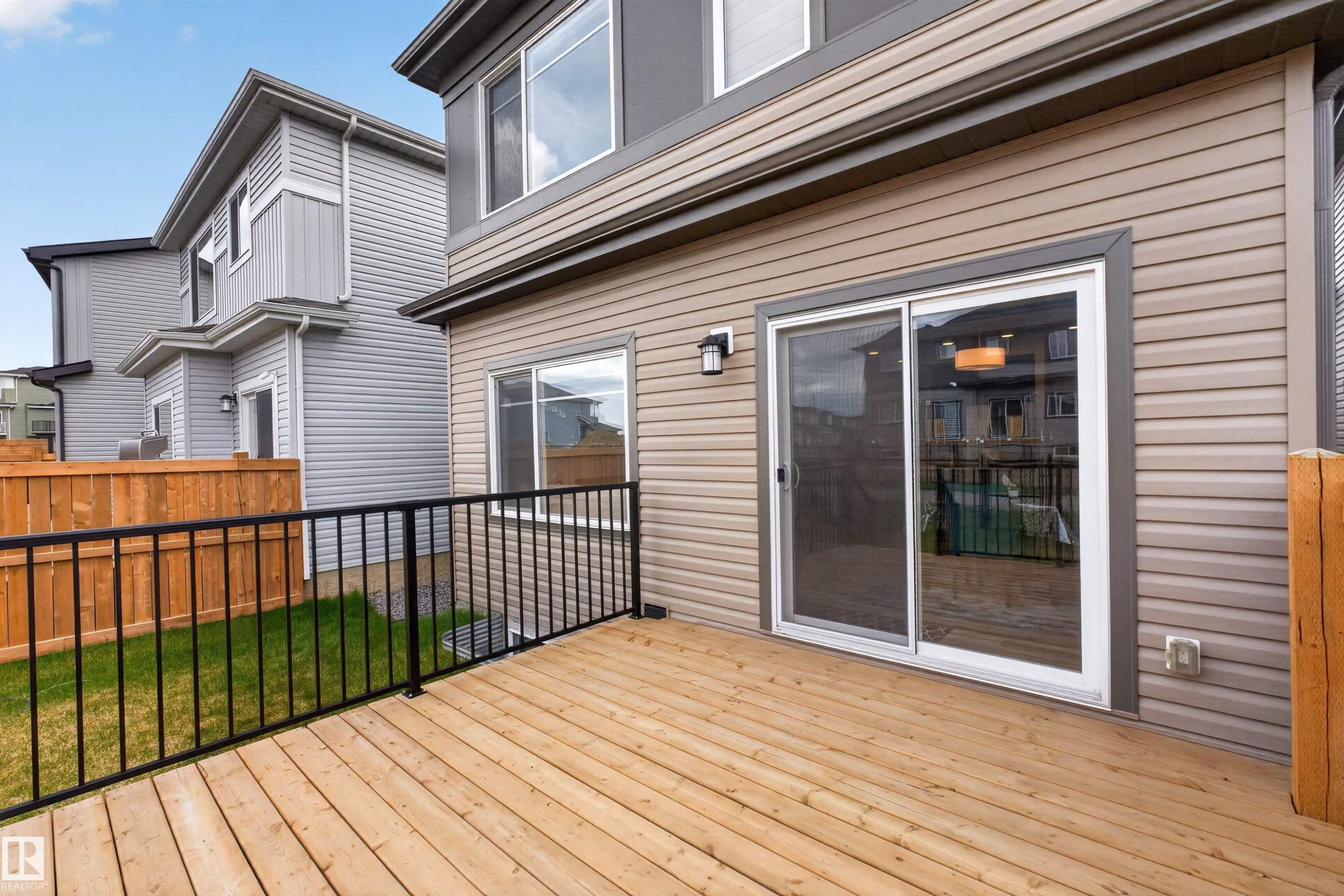 Expansive wood-finish deck with black metal railings - 332 Juniper Cove, Leduc, AB - Outdoor With Deck Patio Veranda With Exterior