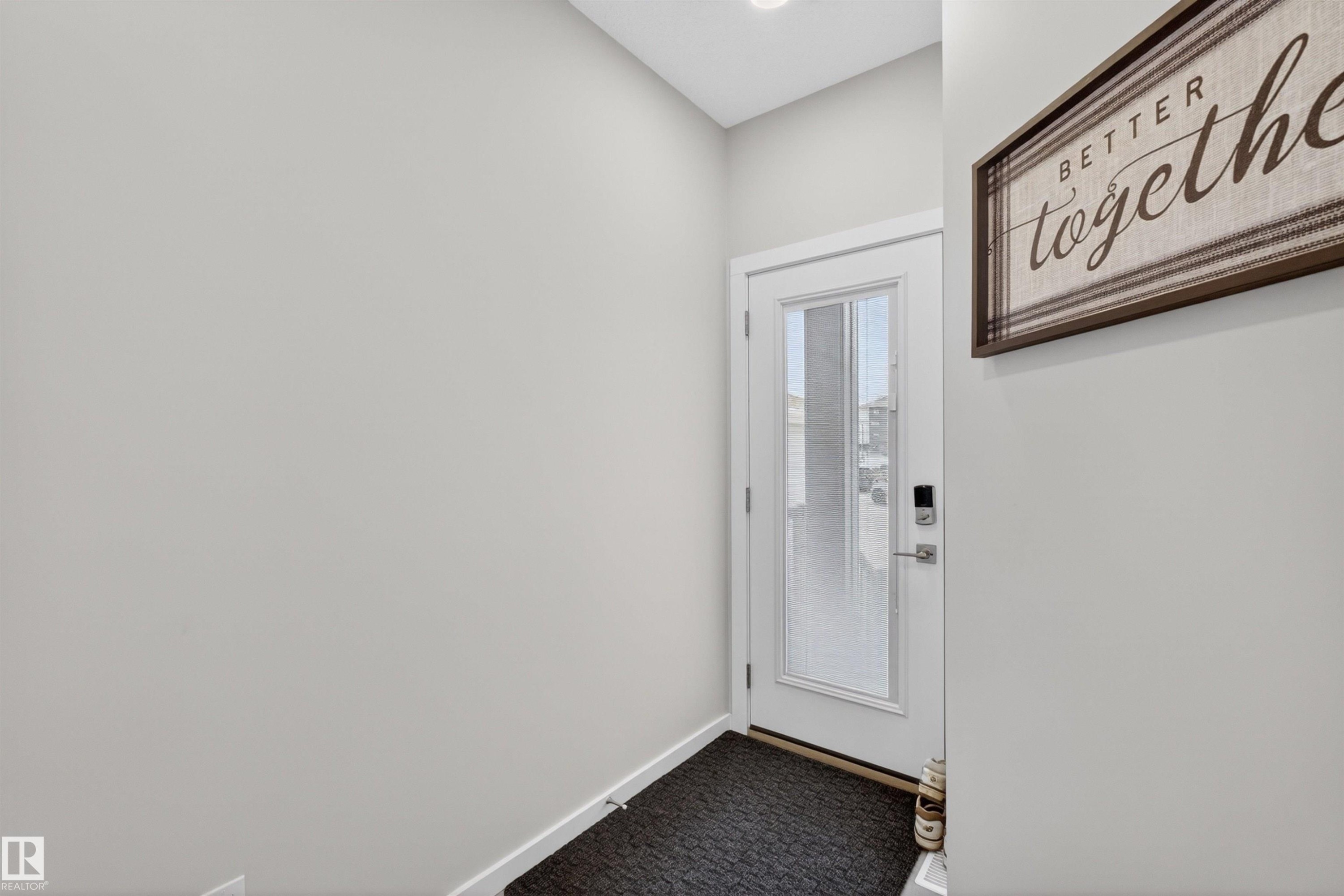 White entry door with frosted glass panel, recessed lighting, and light gray wall paint - 332 Juniper Cove, Leduc, AB - Indoor Photo Showing Other Room