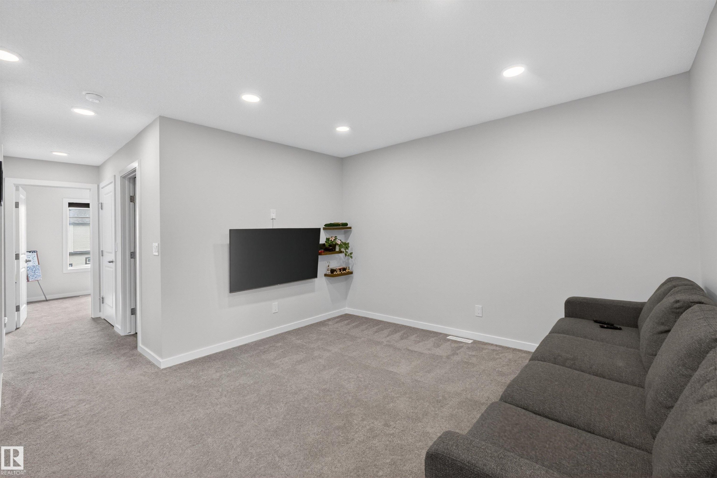 Carpeted room featuring recessed lighting, light gray wall paint, white baseboards, and white door frames - 332 Juniper Cove, Leduc, AB - Indoor