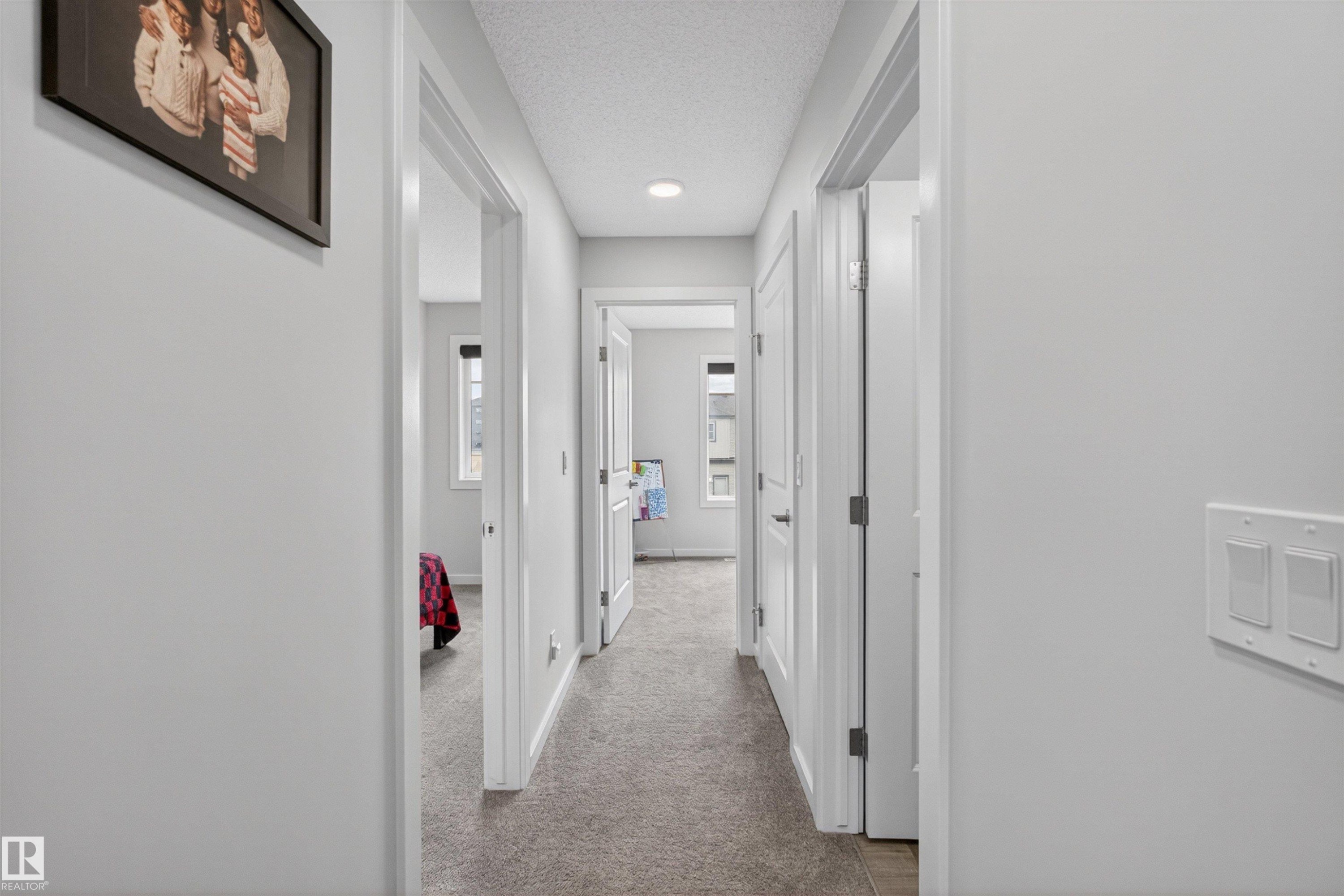 Hallway featuring neutral-toned carpet, recessed lighting, and white trim - 332 Juniper Cove, Leduc, AB - Indoor Photo Showing Other Room