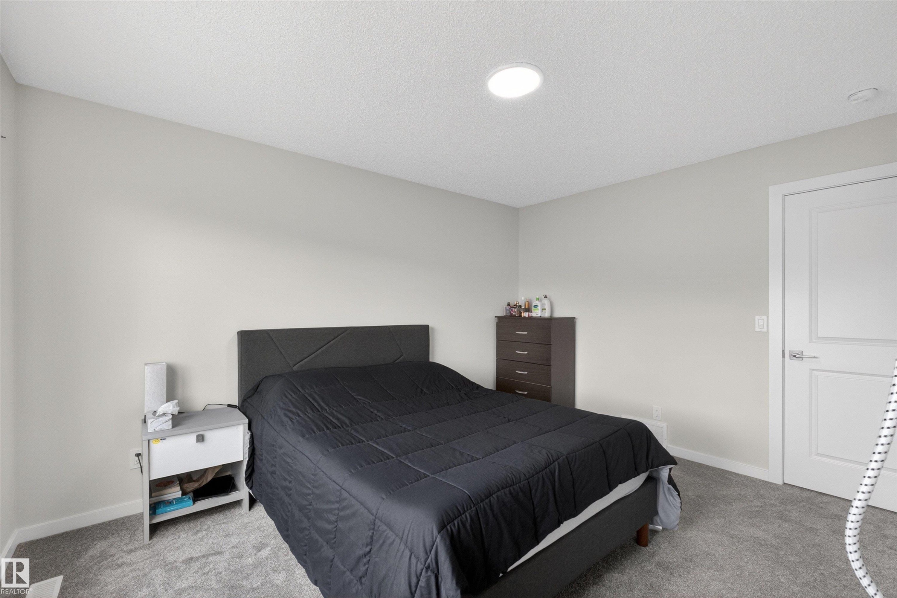Neutral wall color with a textured ceiling and recessed lighting - 332 Juniper Cove, Leduc, AB - Indoor Photo Showing Bedroom