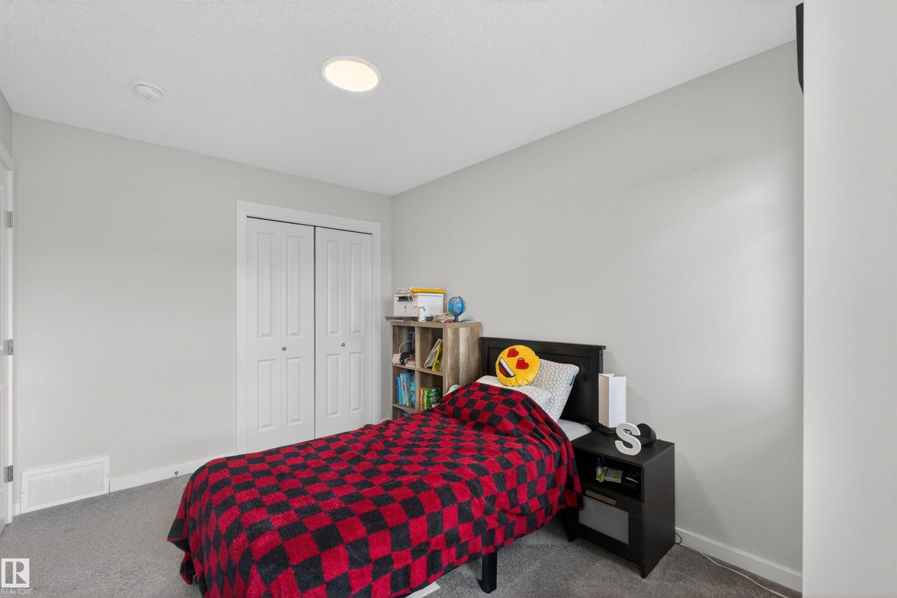 Spacious room featuring light gray walls, plush gray carpeting, white baseboards, and a white ceiling with an integrated recessed light fixture - 332 Juniper Cove, Leduc, AB - Indoor Photo Showing Bedroom