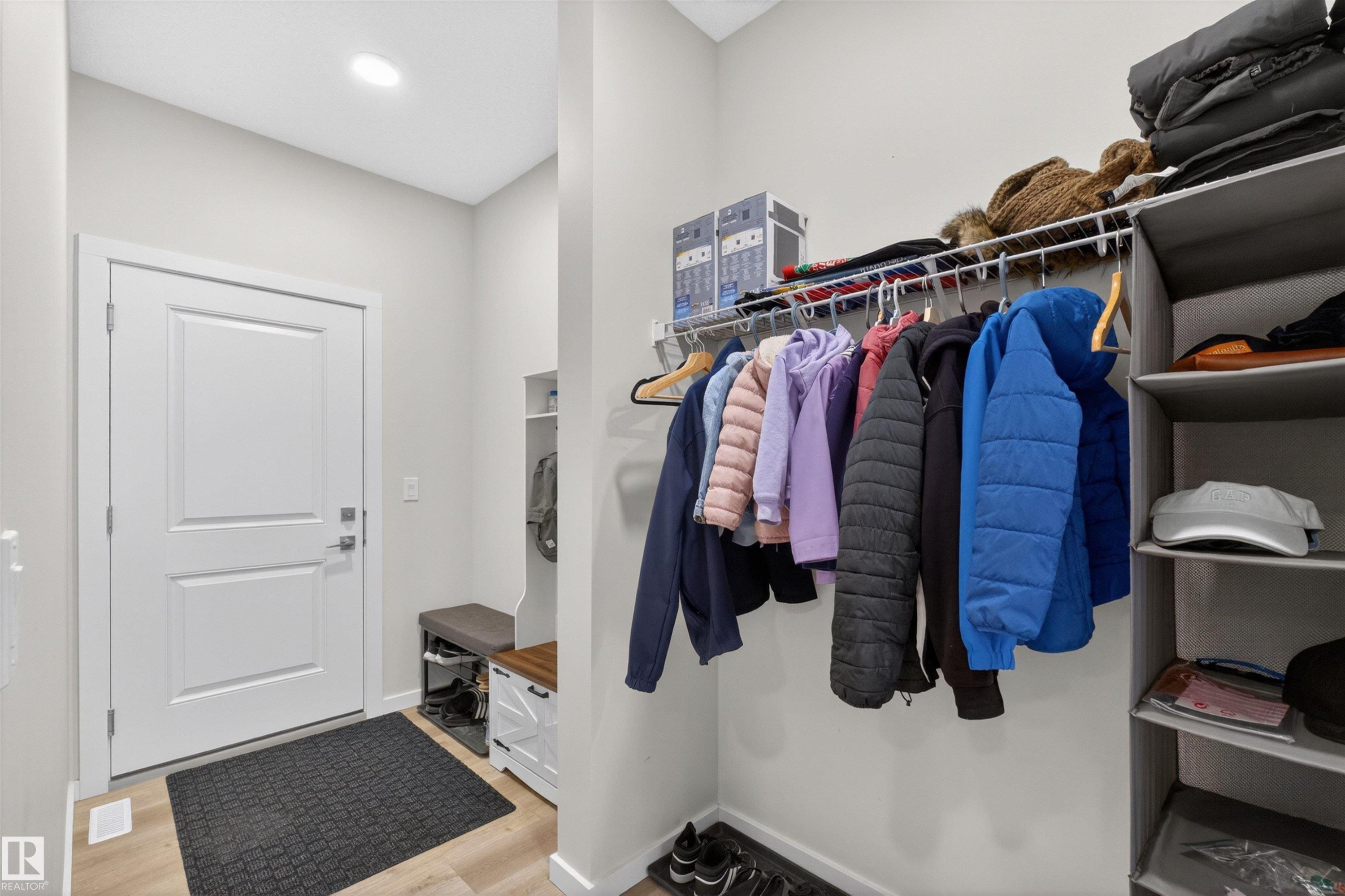 Entryway featuring light wood-finish flooring, a contemporary white door, and recessed ceiling lighting - 332 Juniper Cove, Leduc, AB - Indoor With Storage