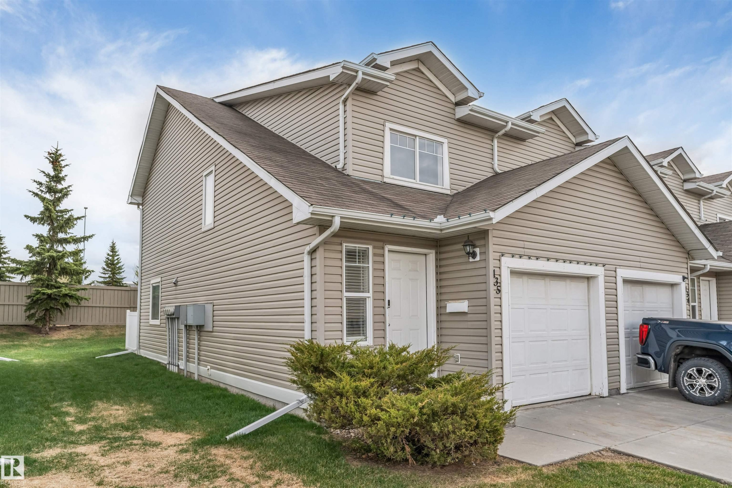Multi-level exterior with light-toned siding, a peaked roofline, and attached garage - 135 150 Edwards Drive, Edmonton, AB - Outdoor