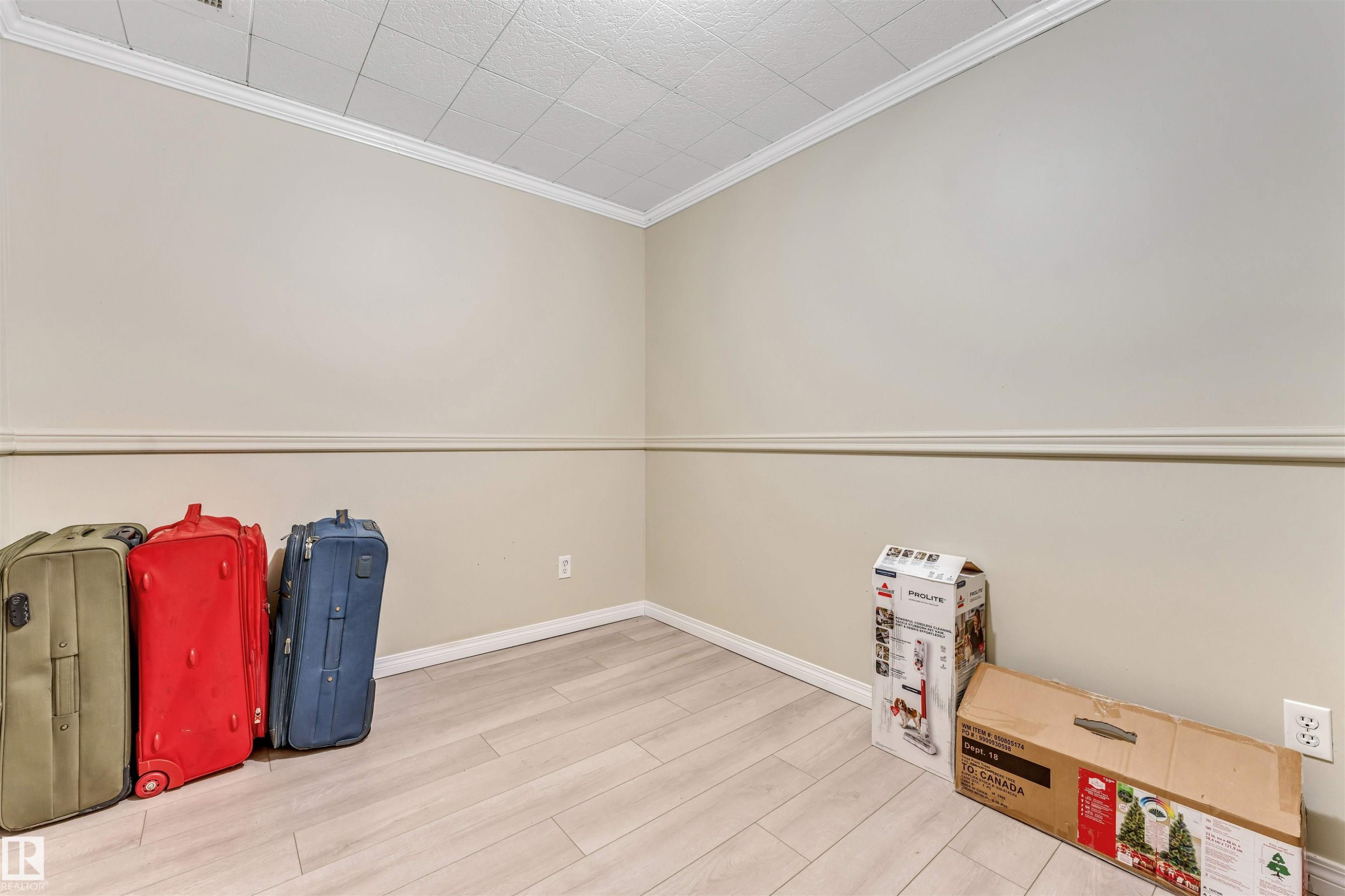 Light-toned walls with chair rail molding, crown molding, and a grid ceiling - 135 150 Edwards Drive, Edmonton, AB - Indoor Photo Showing Other Room