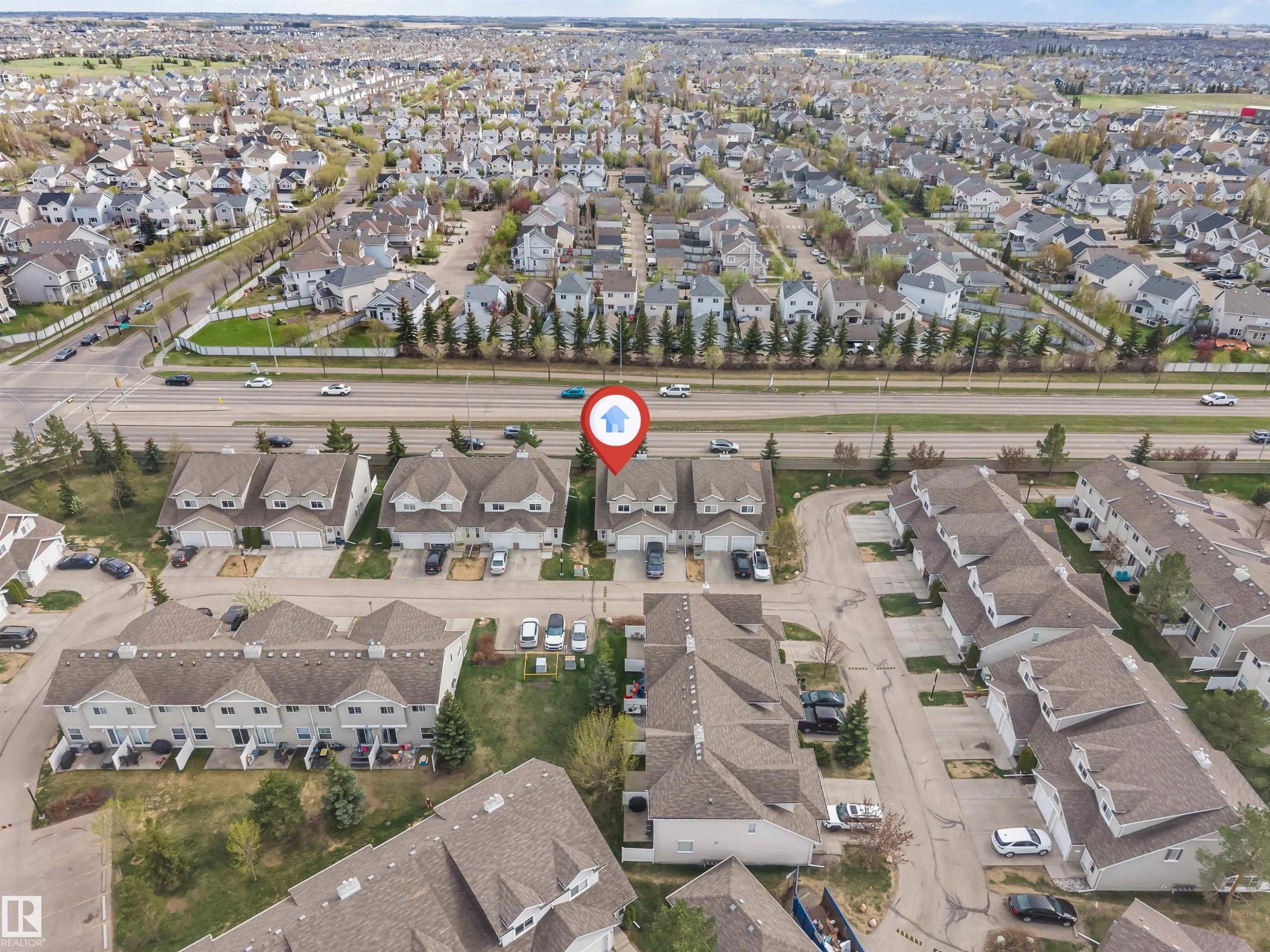 Aerial perspective showcasing a residential community with numerous single-family homes and townhomes - 135 150 Edwards Drive, Edmonton, AB - Outdoor With View