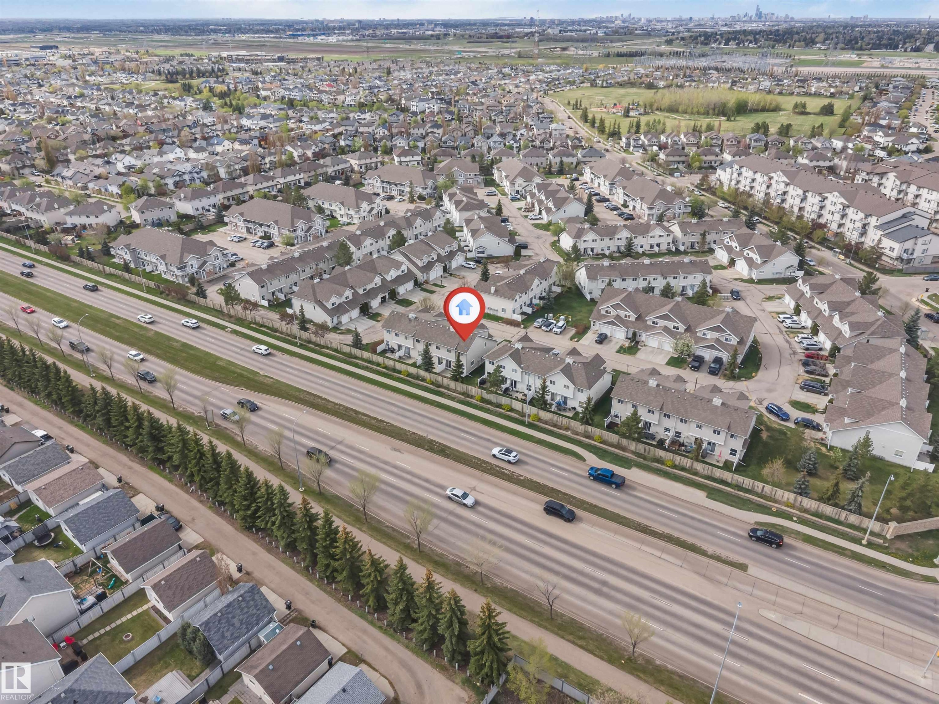 Townhome community featuring multiple buildings with attached garages and paved parking areas - 135 150 Edwards Drive, Edmonton, AB - Outdoor With View