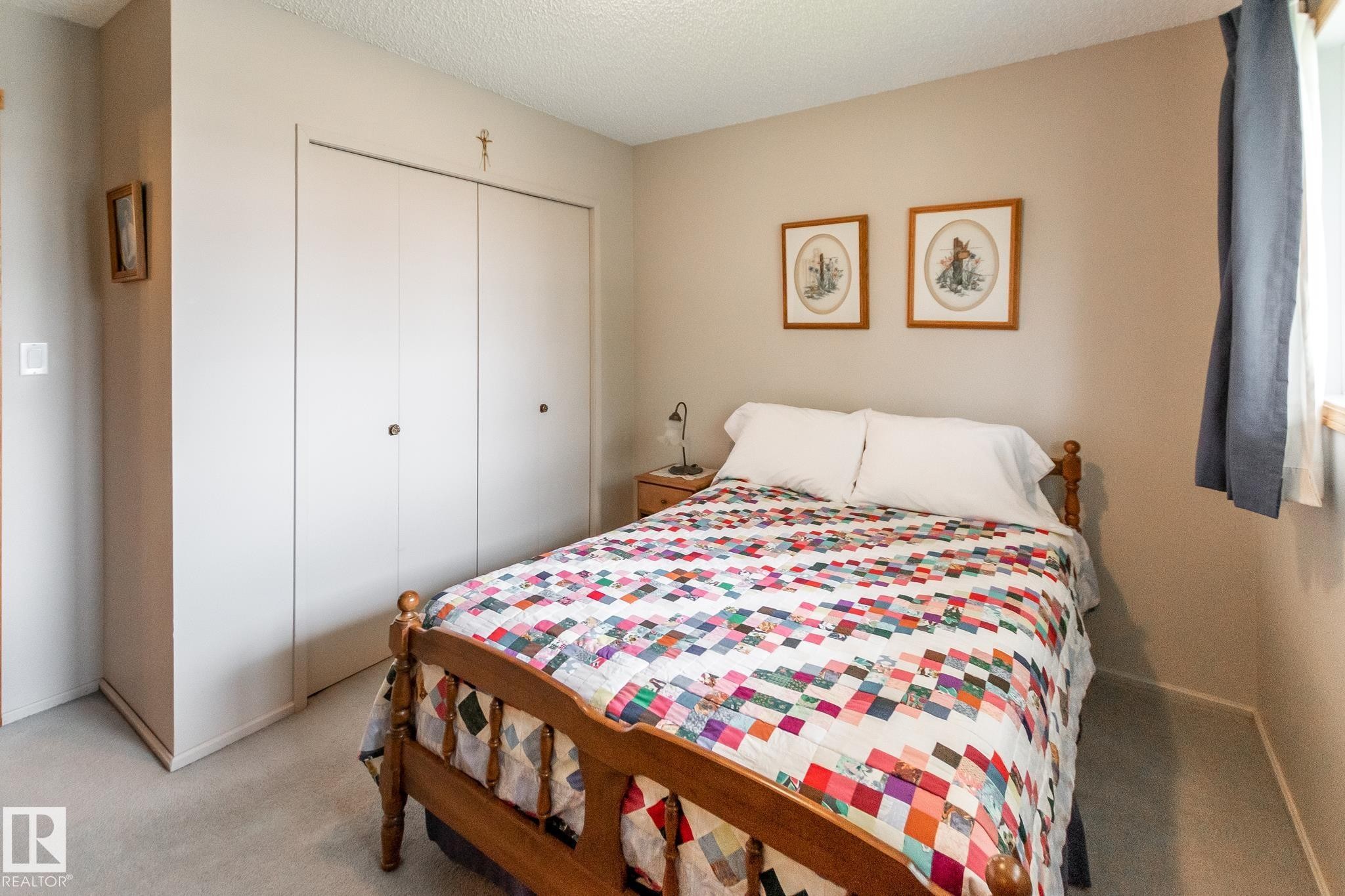 Integrated closet storage featuring bi-fold doors - 4611 Lakeshore Drive, Bonnyville Town, AB - Indoor Photo Showing Bedroom