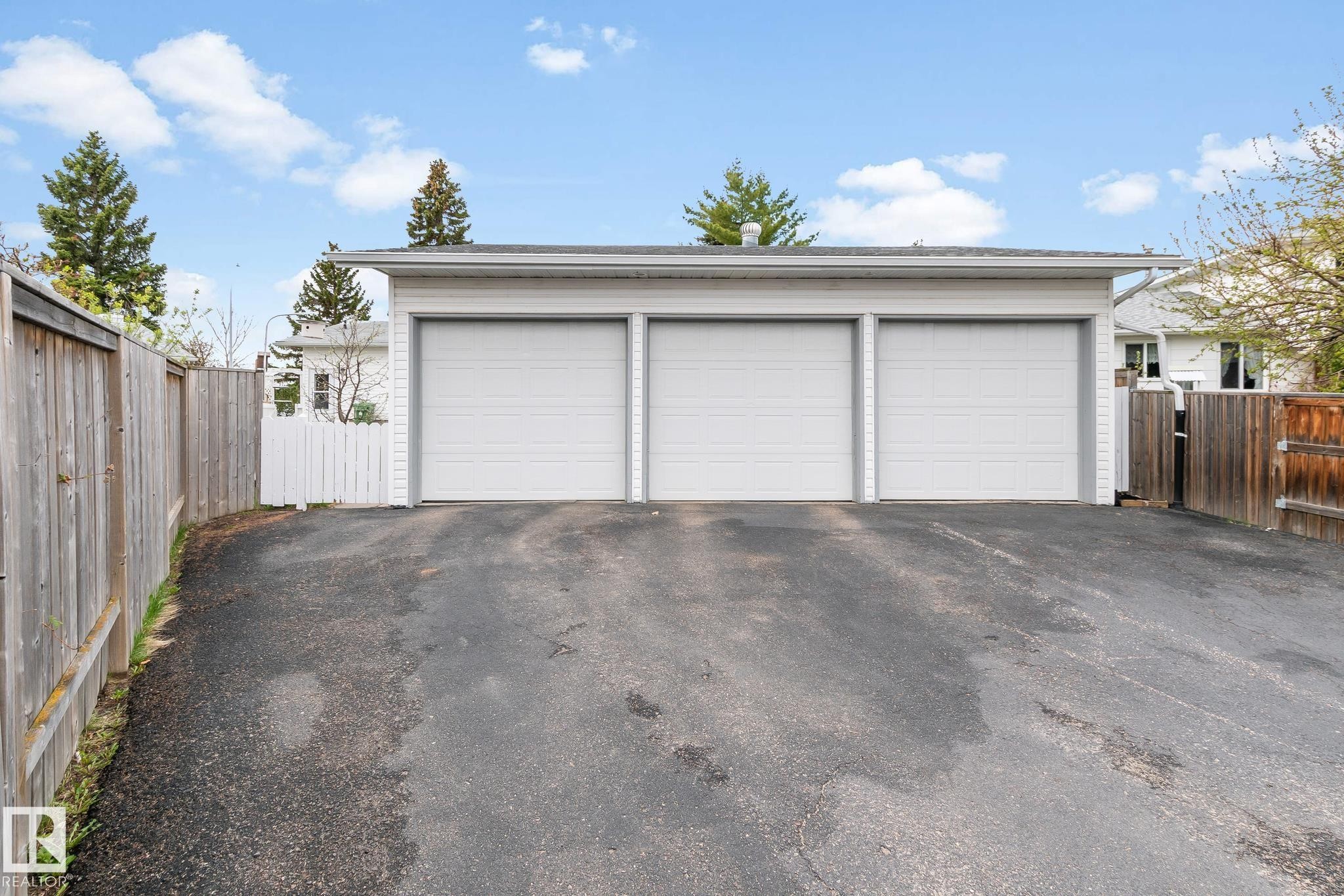 Detached three-car garage featuring three overhead doors and a shingle roof - 4611 Lakeshore Drive, Bonnyville Town, AB - Outdoor