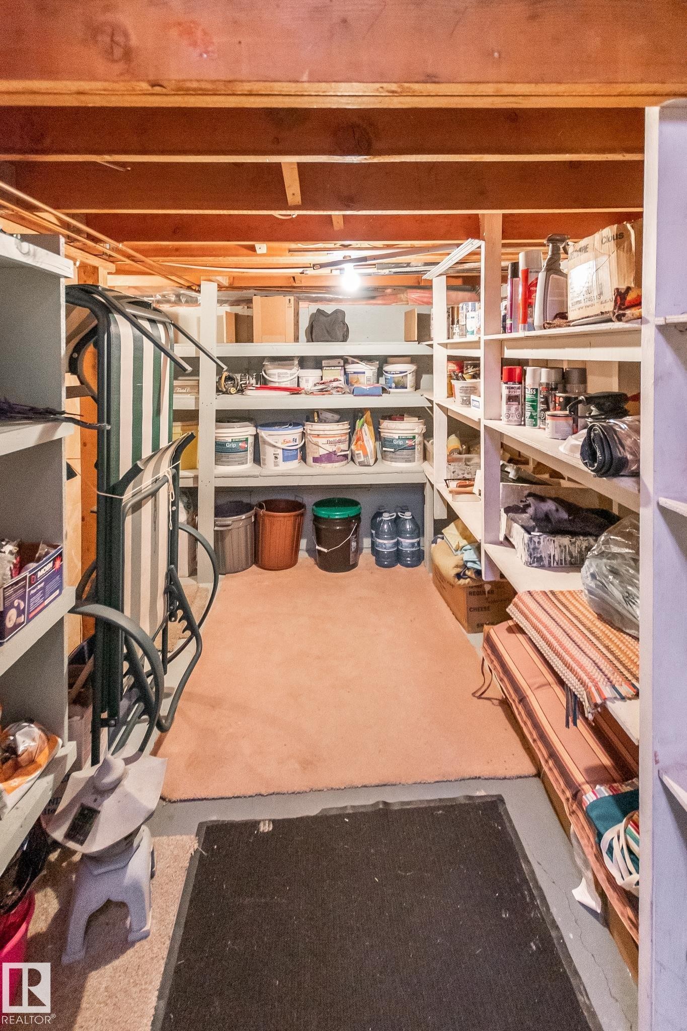 Basement storage area featuring exposed wood joists and multiple built-in shelving units for organization - 4611 Lakeshore Drive, Bonnyville Town, AB - Indoor