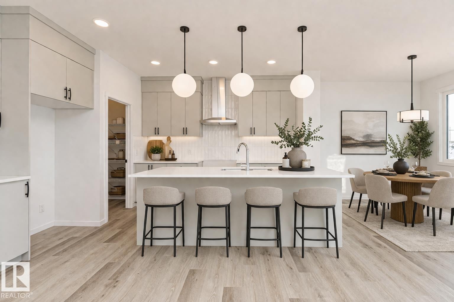 The kitchen features light-colored cabinetry, a white island with seating for four, and pendant lighting - 2355 Egret Way, Edmonton, AB - Indoor Photo Showing Kitchen With Upgraded Kitchen