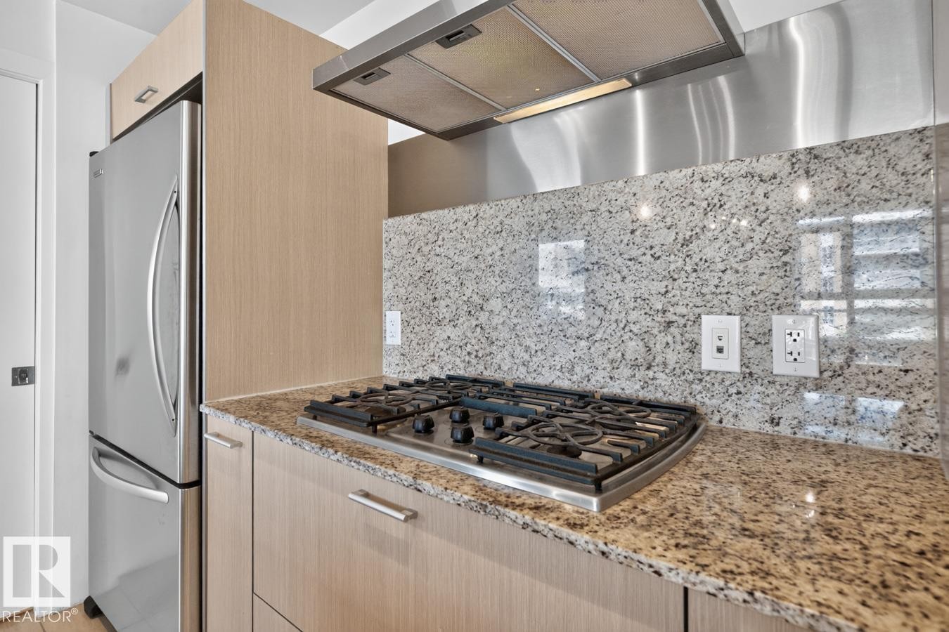 Kitchen featuring a stainless steel refrigerator, four-burner gas cooktop, and a matching stainless steel range hood - #407 2504 109 St Nw, Edmonton, AB - Indoor Photo Showing Kitchen With Upgraded Kitchen