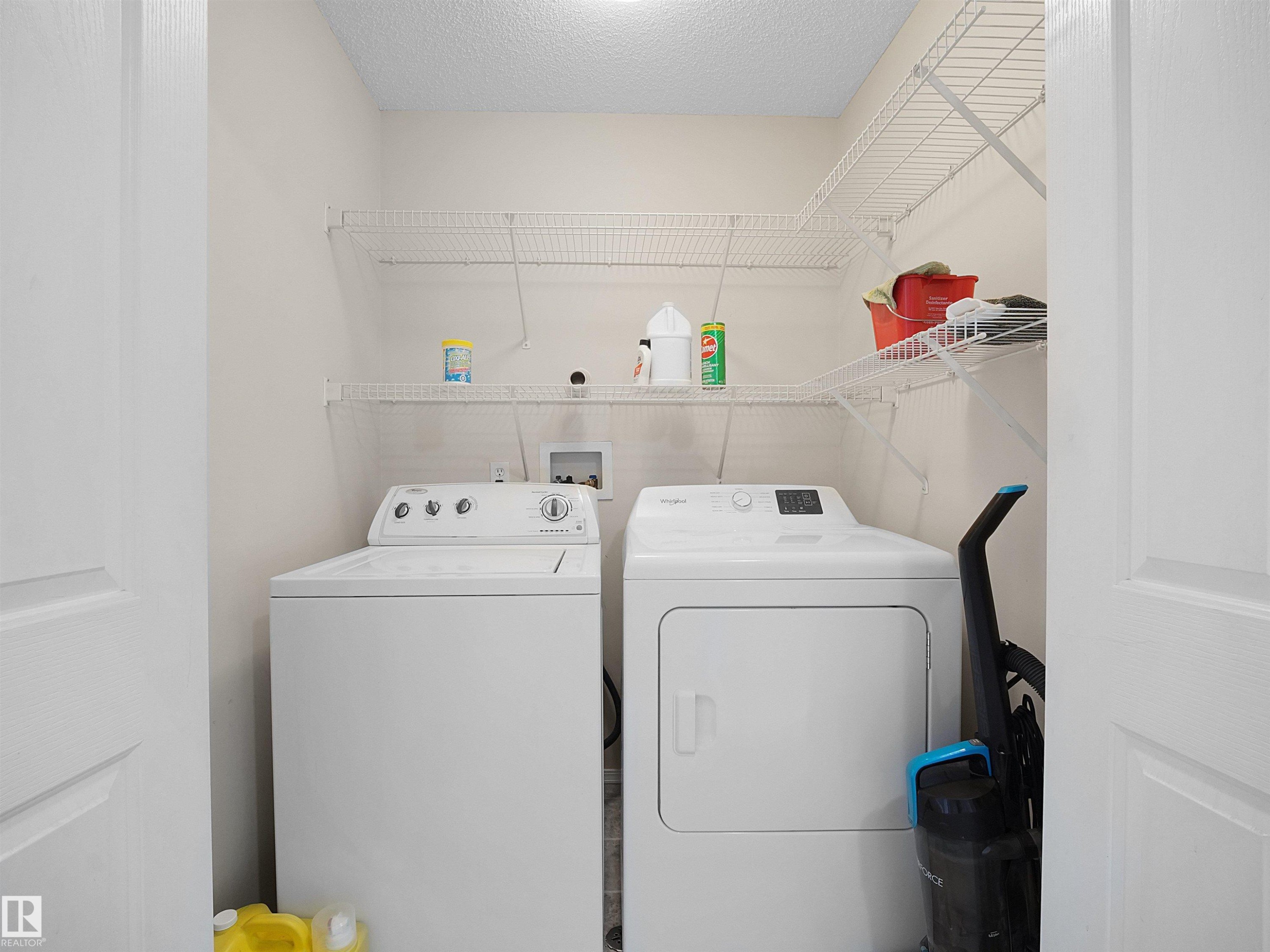 Dedicated laundry area featuring a washer and dryer, complemented by overhead wire shelving for storage - 16121 131A Street, Edmonton, AB - Indoor Photo Showing Laundry Room