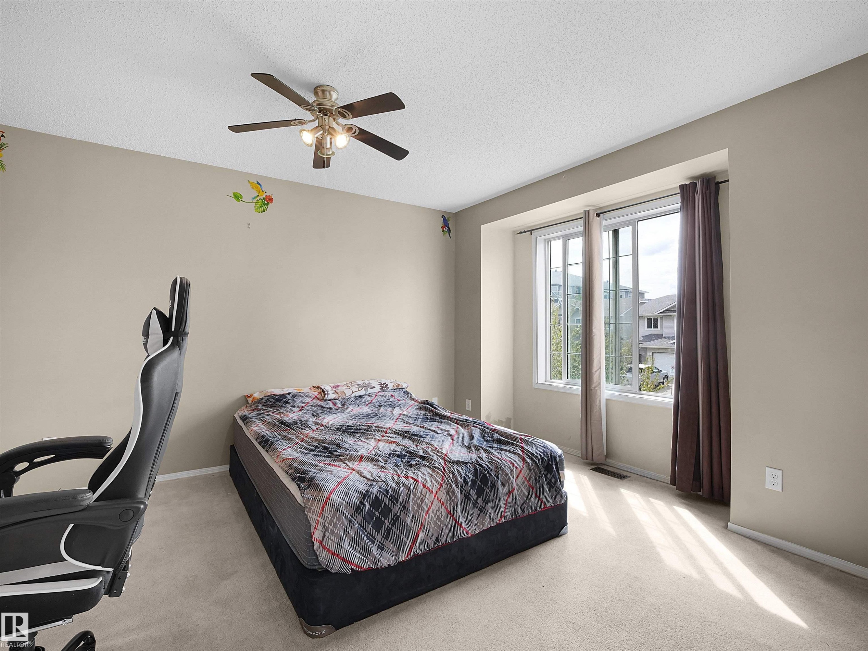 Wall-to-wall carpeting, ceiling fan with integrated lighting, and a large window with white trim - 16121 131A Street, Edmonton, AB - Indoor Photo Showing Bedroom