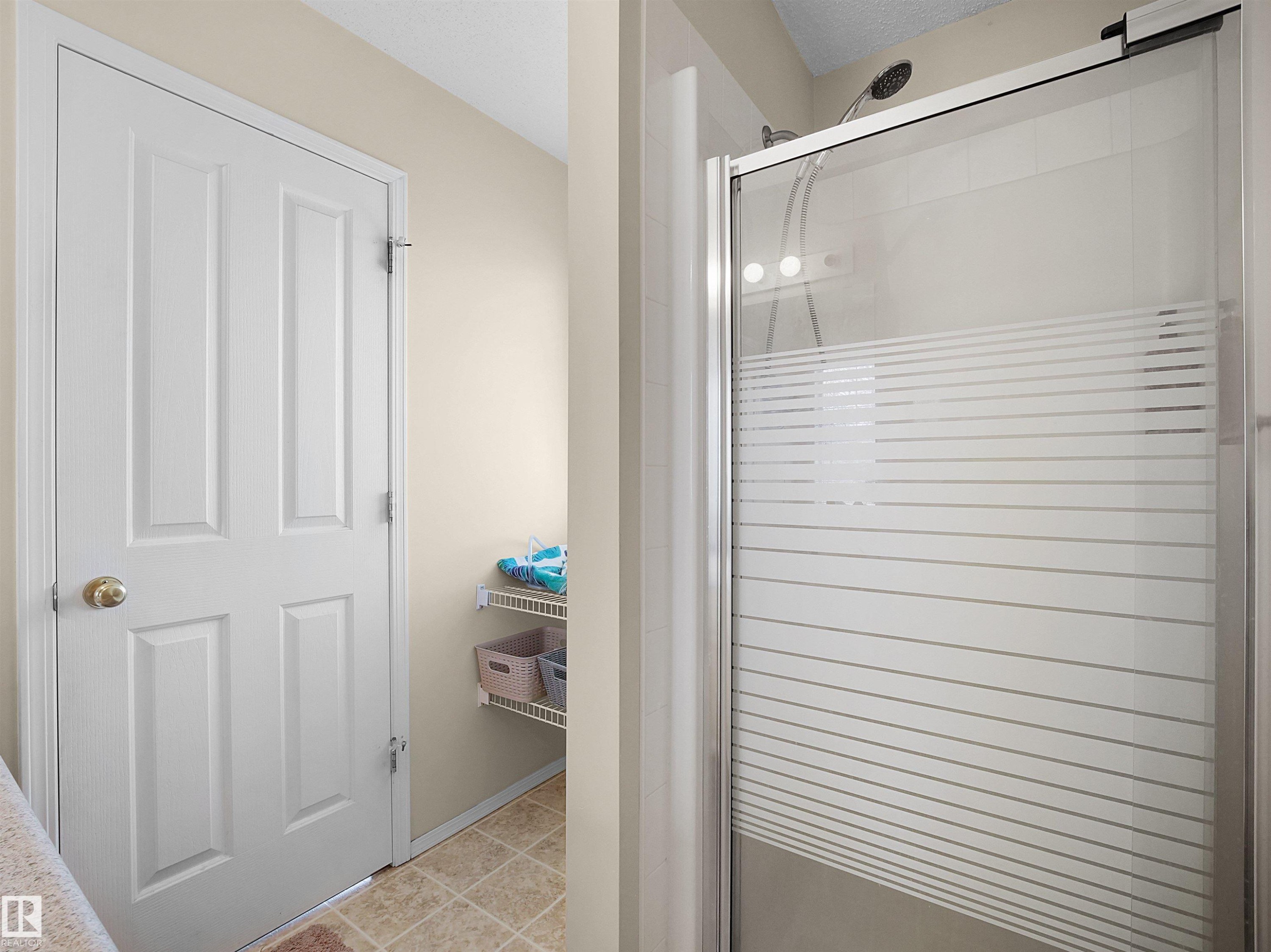 Glass-enclosed shower with horizontal privacy banding - 16121 131A Street, Edmonton, AB - Indoor Photo Showing Other Room