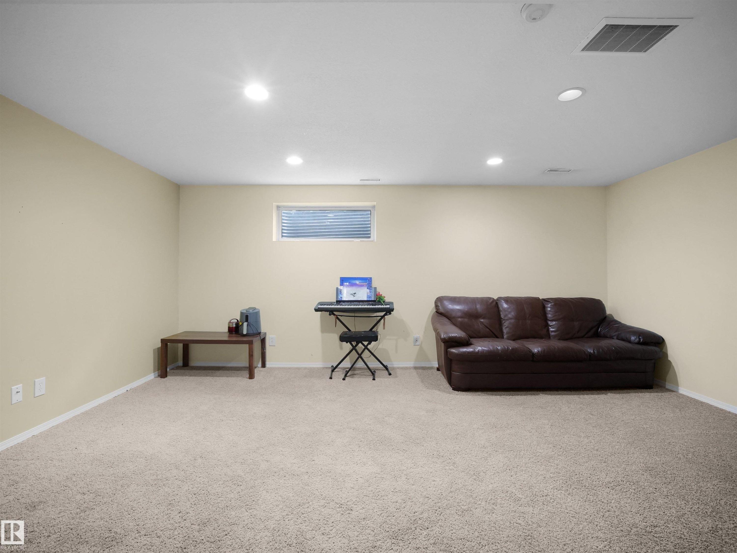 Spacious room featuring neutral carpeting, light-toned walls, and recessed ceiling lighting - 16121 131A Street, Edmonton, AB - Indoor Photo Showing Basement