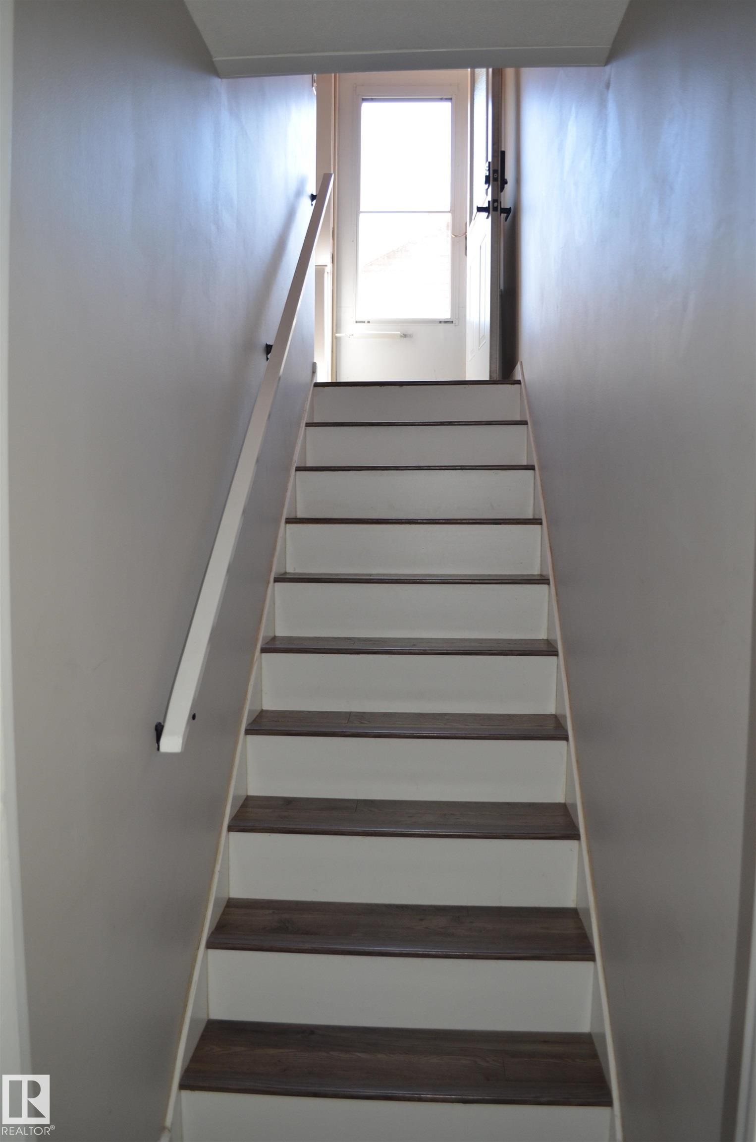 Staircase featuring wood-finish treads and white risers - 10527 81 Street, Edmonton, AB - Indoor Photo Showing Other Room
