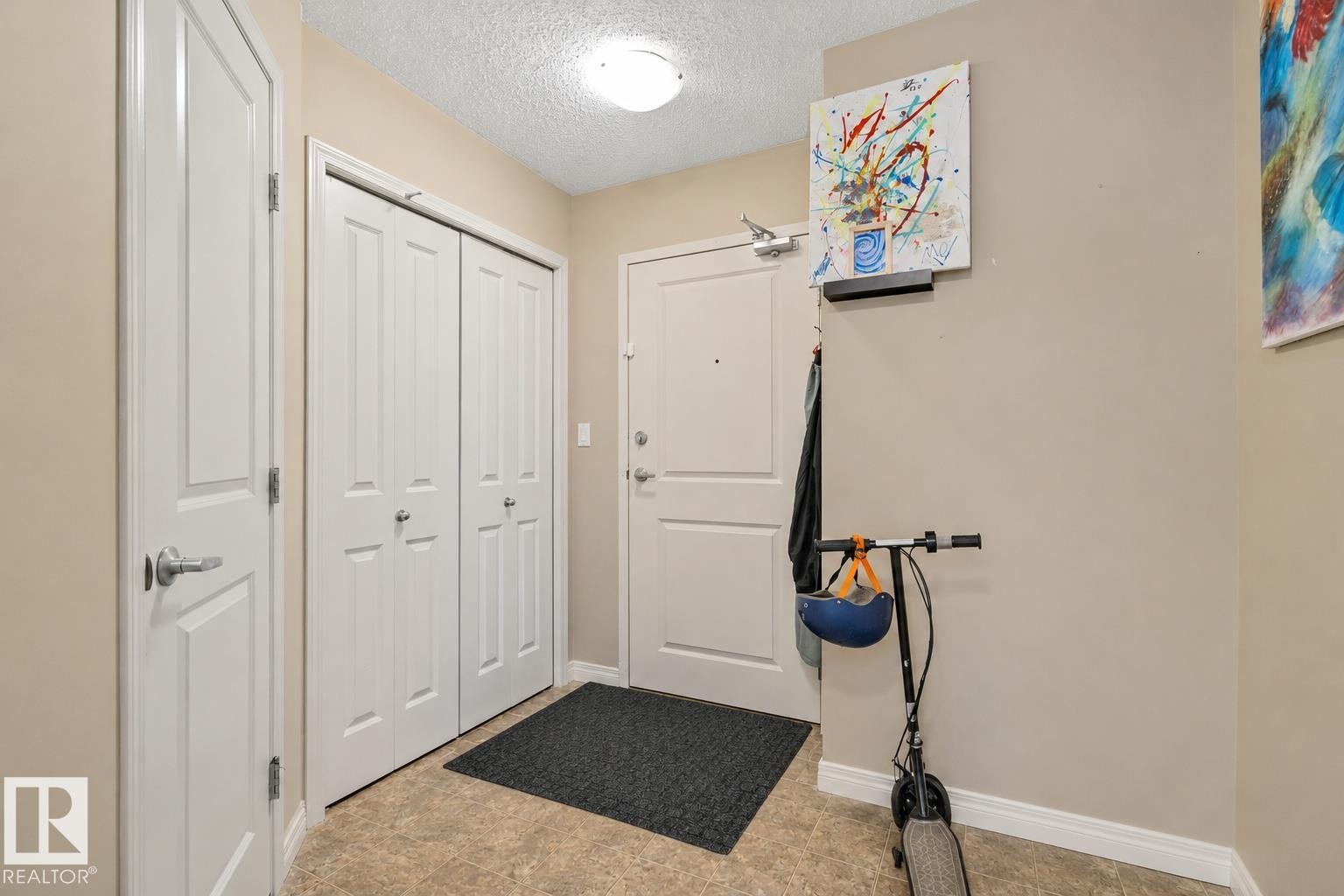 Entryway featuring neutral wall paint, light-toned flooring, white trim, and a flush mount ceiling light - 206 103 Ambleside Drive, Edmonton, AB - Indoor
