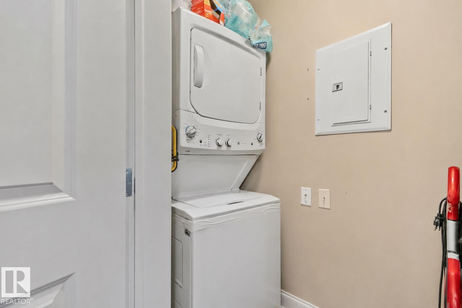 Dedicated laundry area featuring a stacked washer and dryer unit - 206 103 Ambleside Drive, Edmonton, AB - Indoor Photo Showing Laundry Room