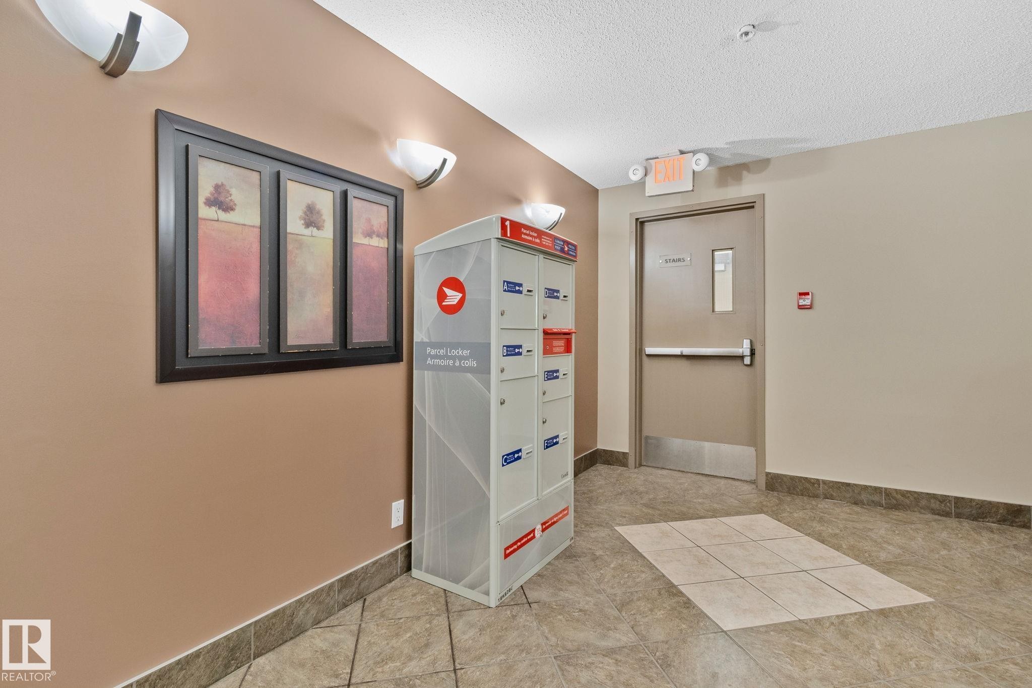 Building common area featuring durable tile flooring, neutral wall tones, and overhead lighting - 206 103 Ambleside Drive, Edmonton, AB - Indoor Photo Showing Other Room
