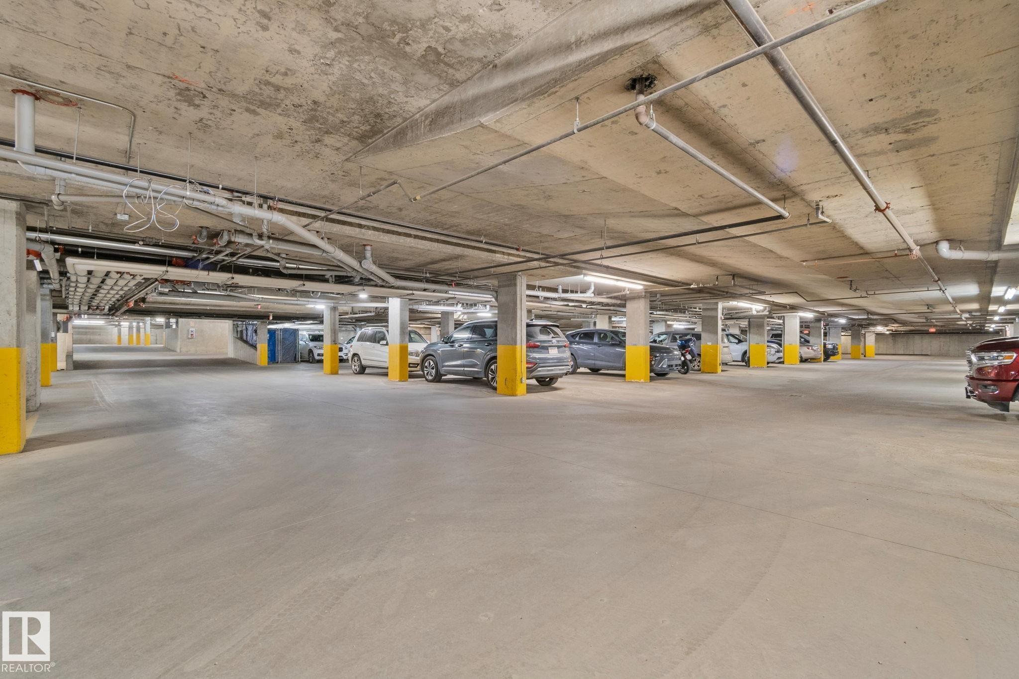 Spacious underground parking garage featuring concrete flooring and ceiling - 206 103 Ambleside Drive, Edmonton, AB - Indoor Photo Showing Garage
