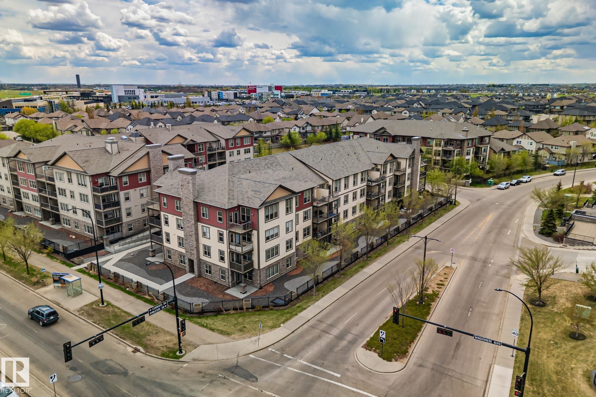 Contemporary multi-story residential building featuring balconies, varied exterior cladding, and mature landscaping - 206 103 Ambleside Drive, Edmonton, AB - Outdoor With View