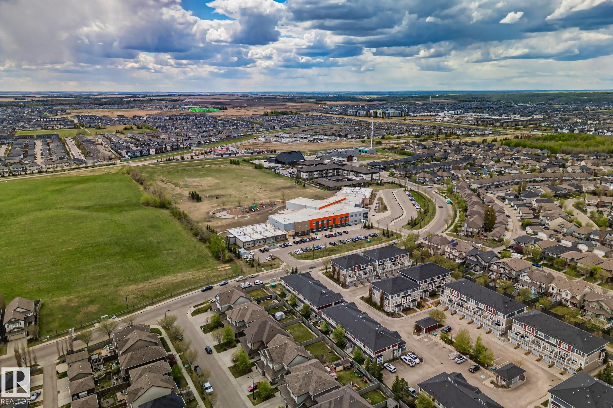 Aerial perspective showcasing a residential area with varied housing types, including single-family homes and multi-story townhouses - 206 103 Ambleside Drive, Edmonton, AB - Outdoor With View