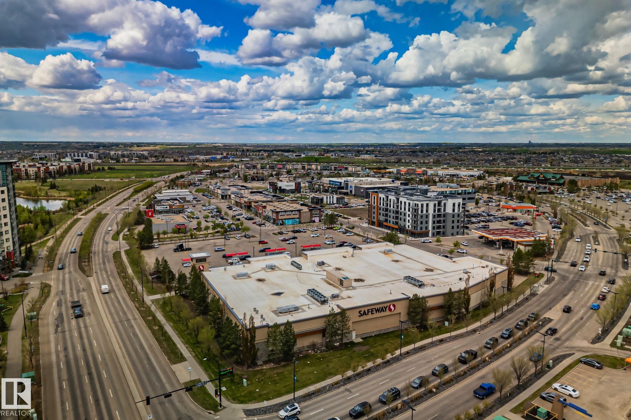Aerial perspective of a commercial district featuring a large grocery store, multiple retail buildings, a gas station, and a multi-lane roadway - 206 103 Ambleside Drive, Edmonton, AB - Outdoor With View