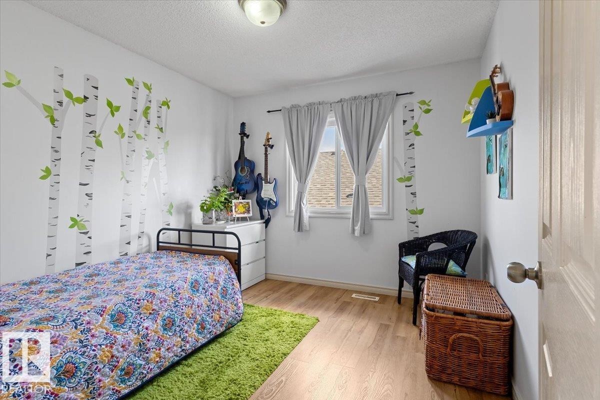 Bright interior space featuring light wood-finish flooring, white walls, and a ceiling-mounted light fixture - 3356 25 Ave, Edmonton, AB - Indoor Photo Showing Bedroom
